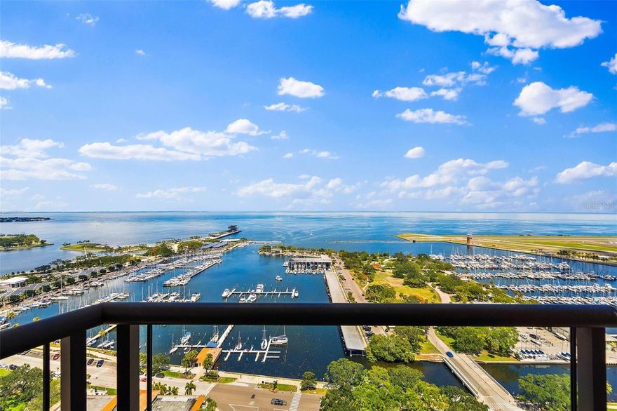 Welcoming and elegant, this penthouse-level “home in the clouds” is situated on the top residential level of Bayfront Tower. The most desirable northeast corner location offers breathtaking panoramic views over Tampa Bay, downtown St Pete, museums, parks and marinas. The Tampa skyline is seen in the distance, and downtown holiday fireworks are enjoyed at eye level. At the end of a quiet hallway, the entrance leads to a lovely foyer before opening to a 41-ft expanse of open dining and living areas and floor - to -ceiling 10 ft tall impact-resistant windows overlooking Tampa Bay and lush green parks. The library / family room is directly off the living room with north and east views, 10- ft. windows and access to the balcony. This beautiful, comfortable room features 2 walls of custom solid wood bookcases. A wet bar serves both library and living room, making entertaining convenient and flexible. The eat-in kitchen has Bosch and Sub Zero appliances, an amazing quantity of custom hardwood cabinetry, and banquette seating at the 5-ft table. Creative elements abound, adding great function and storage. The tranquil primary bedroom has north-facing 10-ft windows, en suite bath, a generous walk-in closet, and 2 additional closets, one with floor to ceiling shelving. The guest bedroom faces east, offering beautiful sunrises and direct water views, a roomy closet, and bath with walk-in shower. Currently used as an office, the 3rd bedroom offers a wall of custom built shelving which surrounds 2 tall north-facing windows and features a generous work area for two. Space to accommodate bedroom or sitting room furnishings, an attached bath with shower and 12' closet. Ample storage space is notable in this home, with two linen closets, a utility closet , a closet with wine fridge for 90+ bottles and a dedicated storage unit conveniently near to apartment. Located on the top residential level of the building, this home is only one flight from the many common amenities found on the 28th floor: fully equipped fitness center, library, sauna, game room, card room, and common social and meeting rooms. The covered walking track and outdoor seating areas are also on 28, with beautiful vistas in all directions. Just two flights up from the home is the outdoor pool area, with gas grills, covered seating areas, herb garden and an open jogging track around the entire perimeter. Such easy access makes using these great facilities a delight.
This condo, situated in a building with panoramic views, 24-hour concierge and valet parking services, beautiful common areas and a quiet oasis so near a delightfully active downtown, brings together all the elements desired in a perfect home.