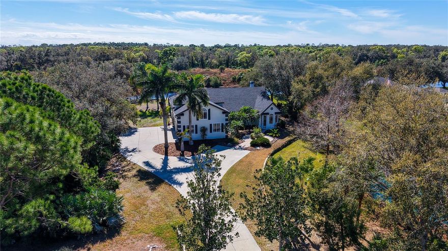 If you're looking for room to breathe, privacy, and water views, look no further than 2098 Palm View Road. Set on nearly an acre in the private, deed-restricted community of Oak Ford, this updated residence offers a rare blend of openness and comfort. Overlooking 2 tranquil ponds, the property enjoys a peaceful, natural setting and offers more than 3,700 sf of living space.
Recent improvements include a new roof in 2023, PGT impact windows and doors, and newer appliances, further enhancing the home’s appeal and move-in readiness.
The four-bedroom, three-bath layout is designed for both comfortable everyday living and effortless entertaining. Vaulted ceilings and an open floorplan enhance the sense of scale, while PGT impact windows and doors provide added protection and efficiency. An oversized foyer creates a welcoming first impression and leads into the main living areas, where unique polished concrete flooring, a central gathering space, and a well-appointed kitchen  with a gas range come together beautifully. The kitchen features custom solid-wood cabinetry, stone countertops, stainless steel appliances, an island with storage, and generous prep space.
The first-floor primary suite creates a private retreat with direct access to the outdoor living area. Two additional bedrooms are located on the main level, while the second floor offers an expansive fourth bedroom or flexible bonus space ideal for a home office, gym, media room, or studio.
Outdoor living is a standout feature of this expansive property. The screen-enclosed, heated pool and spa overlook a south-facing backyard with pond and lush preserve views, offering a serene setting for relaxing or entertaining. A waterside fire-pit seating area adds another inviting destination and the perfect way to end the day. This nearly one-acre homesite also includes an oversized three-car garage and an extended driveway, allowing ample room for parking and storage.
Oak Ford is known for its oversized parcels, custom-built homes, and peaceful setting. Just a short drive west, Waterside Place and Fruitville Commons offer upscale eating and activities. Just a little further, Downtown Sarasota offers acclaimed dining, arts, and waterfront experiences, while St. Armands Circle and the Gulf beaches — including Siesta Key, Lido Key, and Longboat Key — provide some of the area’s most celebrated coastal attractions. In this gorgeous home, you have access to everything Sarasota has to offer, and a sanctuary to retreat to.
