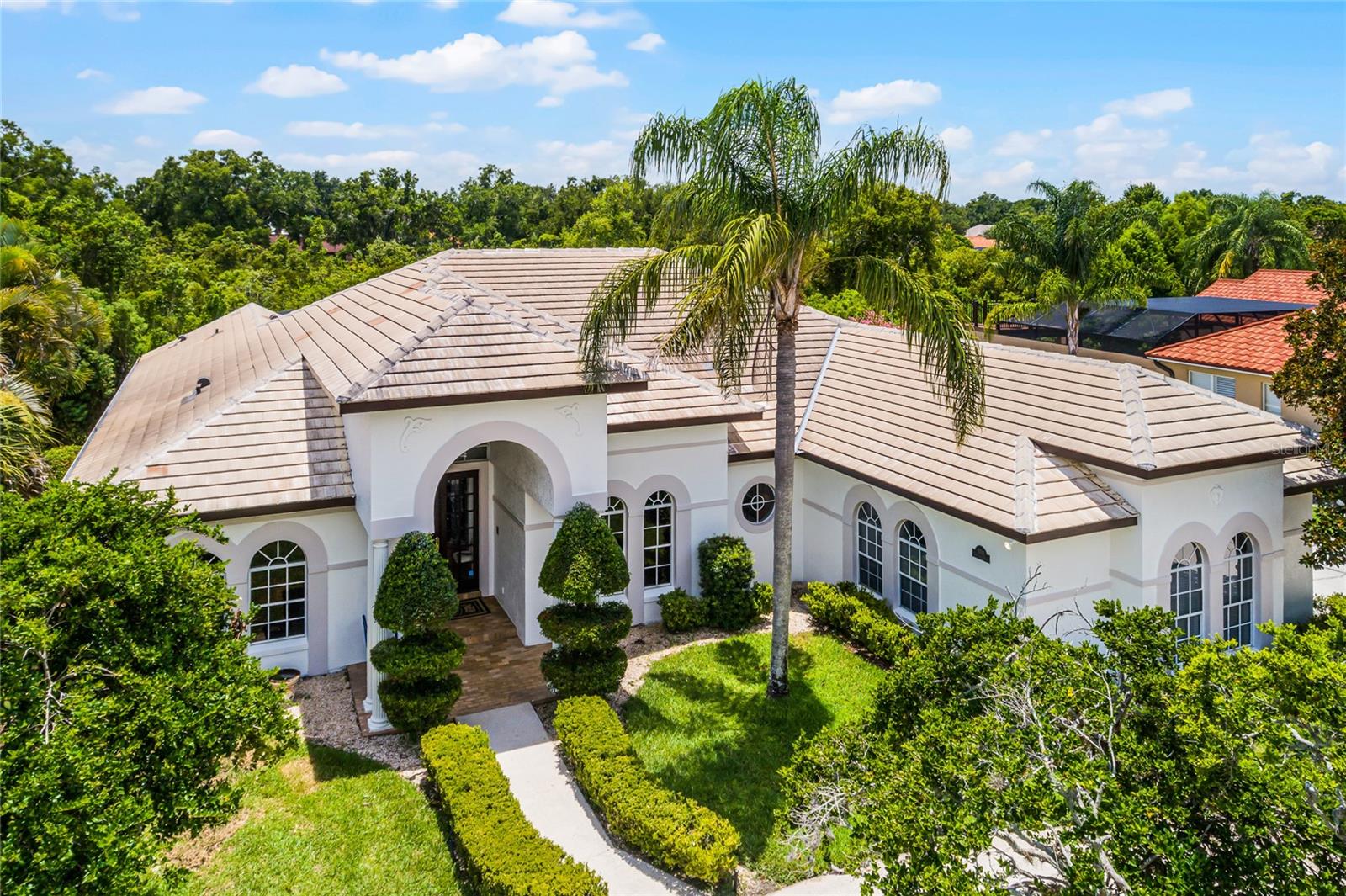 Classic Florida architecture, this custom, single-story home is in highly desirable South Bay in SW Orlando! Located near the community entrance, yet tucked away, and moments to the Sand Lake Road corridor of restaurants and services in the Dr. Phillips area, this stunning property sits on 1/2 acre + and overlooks a Greenbelt. Luxurious interior features include soaring ceilings, French doors, Pecan wood floors, oversized rooms boasting tons of natural Light, custom millwork, large porcelain tile with medallions. An AMAZING fully Renovated Kitchen is a ‘chiefs delight’ - 42’ cabinets, dual purpose breakfast bar & cooking center, granite tops, a full complement of stainless appliances, multiple wine fridges & dishwashers, wet bar & custom backslash! Step down into a huge, bright Family room with stacked stone fireplace, ‘viewing bar’ & French doors, plus spacious Guest bedrooms (Freshly painted!) & 2 full baths down the hall. The opposite side of this U-shaped design includes a front bedroom/bath, the fabulous Primary suite includes an adjoining office/den, vaulted ceilings and an elegant, European-style bath with dual vanities & closets, built-ins, jetted tub, travertine floors, custom shower! Plantation shutters, custom fixtures, an ENORMOUS covered Lanai, pavers surrounding the pool, spa & deck, overlooking Conservation space. Top it off with 3-car side entry garage, circular driveway, barrel tile roof, and a Freshly painted exterior in alabaster tones. A community playground, tennis & pickleball, fishing dock & walking trails, PLUS access to the Bay Hill Club. Not much more to want!