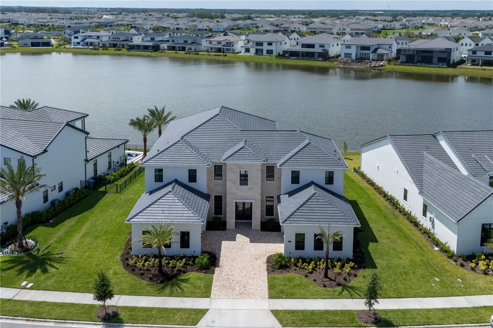 One or more photo(s) has been virtually staged. One or more photo(s) have been virtually staged.
Welcome to a stunning newly built Toll Brothers residence, offering the pinnacle of modern luxury living in the distinguished gated community of Laurel Pointe, Lake Nona. Set on a premium lakefront lot, this exceptional home spans 6,632 square feet of refined interior space, combining elegance, functionality, and a sleek contemporary design with no carpet throughout.
With 5 spacious bedrooms, a thoughtfully designed cabana bathroom, and two dedicated office spaces—one on the first floor and another upstairs—this residence is ideal for families, professionals, and entertainers alike. Whether working remotely, studying, or managing a business, you’ll find inspiring spaces tailored for productivity and privacy.
The expansive open floor plan is highlighted by soaring ceilings, clean architectural lines, and seamless indoor-outdoor flow, allowing natural light to illuminate every corner of the home.
At the heart of the home lies a chef-inspired gourmet kitchen, equipped with top-of-the-line appliances, a large center island, and exquisite finishes. The kitchen effortlessly connects to the dining and living areas, creating an inviting space for family gatherings and hosting guests.
Retreat to the luxurious primary suite, a true private haven overlooking serene lake views. The spa-style en-suite bathroom features an oversized glass-enclosed shower, modern freestanding soaking tub, dual vanities with smart mirrors, and sleek cabinetry—all curated with designer finishes for a refined experience.
Additional highlights include a private movie theater room, perfect for cinematic evenings at home with family and friends.
Step outside to enjoy breathtaking lake vistas, beautifully landscaped surroundings, and a covered patio ideal for al fresco dining or relaxing by the water’s edge. The cabana bath ensures convenience for outdoor living and future pool use.
This brand-new construction by Toll Brothers offers modern finishes, energy-efficient systems, and the comfort of move-in-ready luxury.
Laurel Pointe offers residents an exceptional lifestyle within the Lake Nona master-planned community, known for its innovation, wellness, and connectivity. Enjoy access to scenic trails, parks, art installations, and an autonomous shuttle service that connects the neighborhood to nearby attractions and amenities. You're just minutes from Lake Nona Medical City, USTA National Campus, Orlando International Airport, and a curated selection of shopping, dining, and entertainment.
With dual 2-car garages, abundant storage, and an unbeatable location, this home presents a rare opportunity to own a piece of Central Florida’s most dynamic and sought-after community.
Schedule your private showing today and experience elevated lakefront living in Lake Nona’s Laurel Pointe.