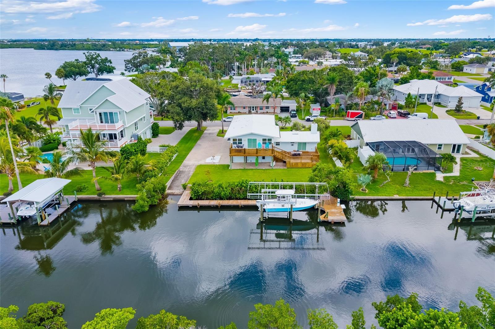 Welcome to Snead Island and discover the ultimate combination of privacy, luxury, and waterfront living in this beautifully updated 3-bedroom, 3.5-bath, 4 car garage home with your own private boat ramp. Tucked away in a serene setting, this property offers a rare level of seclusion while still providing direct access to the Manatee River making it perfect for boating, fishing, and enjoying Florida’s coastal lifestyle. From your backyard, launch directly into adventure with your private boat ramp and boat lift on a deep-water canal just minutes from open water. Whether it’s a sunrise fishing trip or a sunset cruise, your boating days couldn’t be easier. Step inside to a newly renovated kitchen, featuring upscale cabinets, huge quartz counters, and stainless appliances that make cooking and entertaining a delight. The open-concept layout flows effortlessly into the living and dining areas, all filled with natural light through hurricane-impact windows. Retreat to the private primary suite, complete with an en-suite bath and large closet. Two additional bedrooms provide flexibility for guests, family, or a home office. One bedroom having its own entrance making it a great option for an in-law suite. Outside, lush tropical landscaping frames your waterfront oasis. The secluded double level deck and large covered paver patio allows you to relax in complete privacy while watching the wildlife from your own backyard. This home also features a four car garage, ample parking space, and a circular driveway. Just minutes from Emerson Point Preserve, Bradenton Yacht Club, all your shopping needs and easy access to major highways and Florida beaches. Schedule your private showing today!