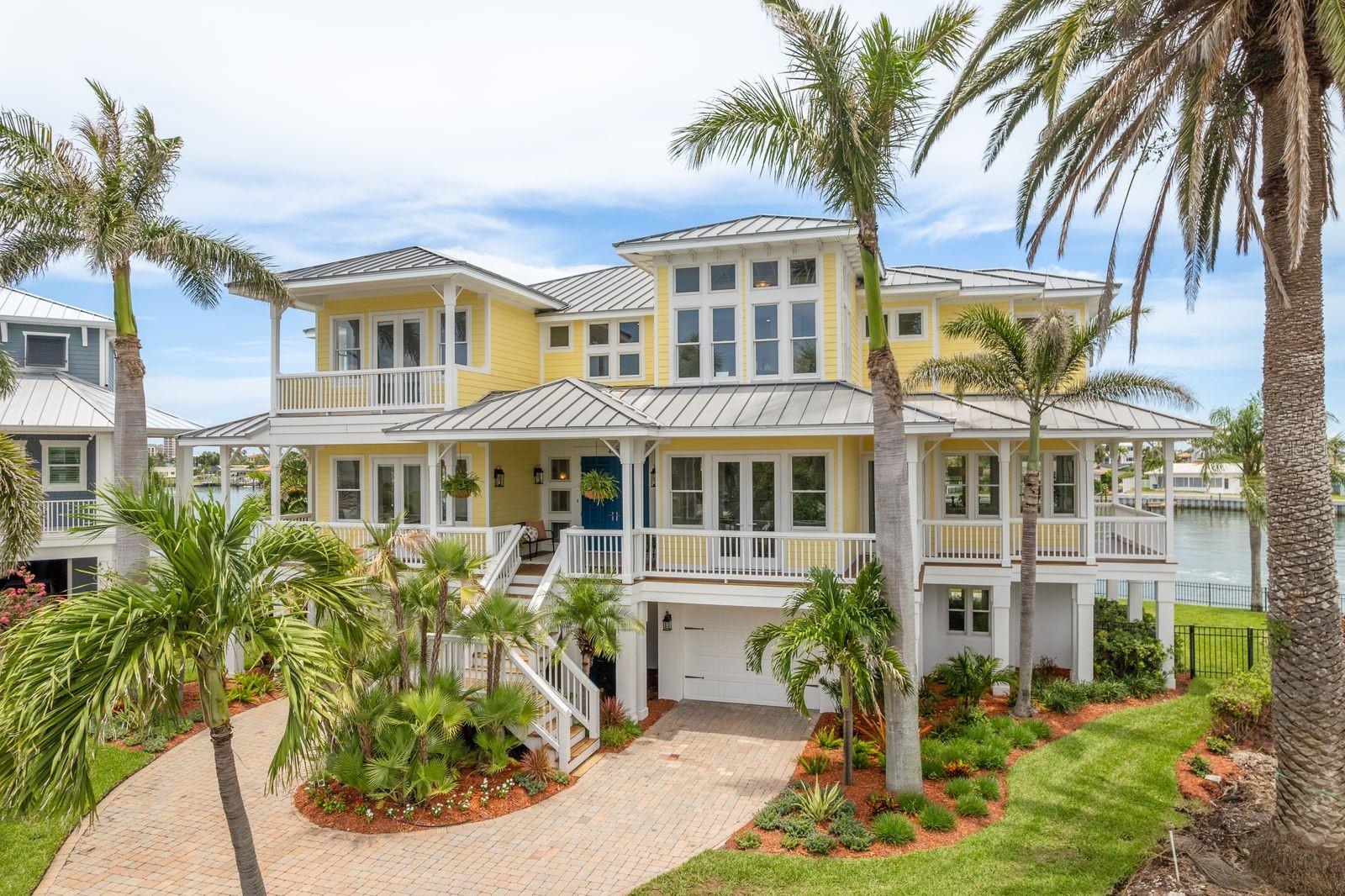 One-of-a-Kind Island Estates Waterfront Masterpiece
Welcome to an extraordinary waterfront retreat in the prestigious and highly sought-after community of Island Estates. Perfectly positioned at the end of the island on deep, open water, this exceptional residence offers 150 feet of pristine water frontage, providing the ultimate haven for boating enthusiasts - with space to accommodate any size vessel you desire.
From the moment you arrive, the home's curb appeal is undeniable. A welcoming driveway, beautifully manicured landscaping, and graceful palm trees create a peaceful, tropical setting. Thoughtfully constructed with superior craftsmanship, this elevated Key West-style home rests atop nearly 50 reinforced pilings, offering lasting strength, security, and peace of mind against Florida's coastal storms.
Spanning over 9,000 total square feet (4,000 square feet under air) across three thoughtfully designed levels, this property offers versatility, luxury, and space in abundance. The ground level includes two separate garages and an enormous storage area - ideal for multiple uses such as a gym, workshop, hobby space, or simply an incredible amount of storage for all your toys and gear.
On the main living level, a wrap-around veranda welcomes you to relax and take in the endless water views. Step inside to soaring 20-foot ceilings, walls of windows (nearly 100 in total!) and gleaming Brazilian cherry wood floors that create warmth and elegance throughout the space. Wherever you stand, you're greeted by breathtaking water vistas - it's impossible not to be inspired by the beauty surrounding you.
The heart of the home is the expansive, open-concept great room and gourmet kitchen, designed for both entertaining and everyday living. A beautifully appointed wet bar makes hosting friends and family effortless. For more formal gatherings, enjoy the elegant dining room or unwind in the charming sitting room/parlor. A private guest suite with its own en-suite bath completes this level, offering comfort and privacy for visitors.
Upstairs, the primary suite is a true retreat - complete with vaulted cathedral ceilings, a private balcony overlooking the water, and a recently renovated, spa-inspired en-suite bathroom featuring luxurious finishes, an oversized walk-in shower, soaking tub, and dual vanities. The custom wrap-around closet offers exceptional storage and organization. Three additional bedrooms, each with either an en-suite or Jack-and-Jill bathroom, ensure that every family member or guest has their own private haven- and each has a balcony with captivating water views.
And for the grand finale - ascend to the one-of-a-kind rooftop sun deck, thoughtfully engineered to support a hot tub if desired. From this exclusive perch, enjoy unmatched 360-degree views of Island Estates, the Intracoastal Waterway, and Clearwater Beach - truly the best view in town. Whether savoring sunsets, hosting gatherings, or simply soaking in the peaceful surroundings, this private rooftop escape is unforgettable.
With deep water access, robust construction, designer finishes, endless storage potential, and panoramic views from every corner of the home, this Island Estates masterpiece is a rare and exceptional offering - where luxury, comfort, and coastal living come together in perfect harmony.