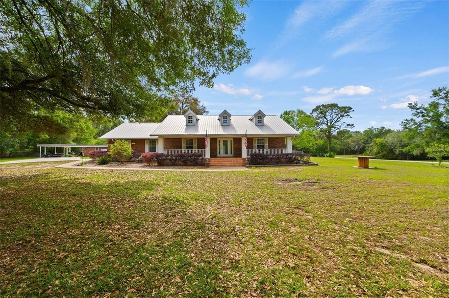 Tucked just over the Alachua County line in Newberry, this charming 3-bedroom, 3-bath, brick home sits on 5 beautiful acres, offering the perfect blend of comfort, space, and versatility. Inside, a well-designed layout features formal living and dining rooms, a cozy family room, and a spacious kitchen with additional dining space, separated by a distinctive brick accent wall.
The split floor plan provides privacy for the primary suite, complete with a dedicated office, walk-in closet, and a generously sized bathroom. On the opposite side, two additional bedrooms and baths offer comfortable accommodations for family or guests.
Enjoy Florida living with a screened-in pool, updated pool deck, and convenient pool bath.
The property also offers exceptional storage and workspace, including a massive metal building with height to accommodate RV parking and space to store multiple vehicles a boat etc., plus additional storage buildings and a dog kennel.
A rare combination of acreage, functionality, and location—just minutes from town with the privacy of country living.