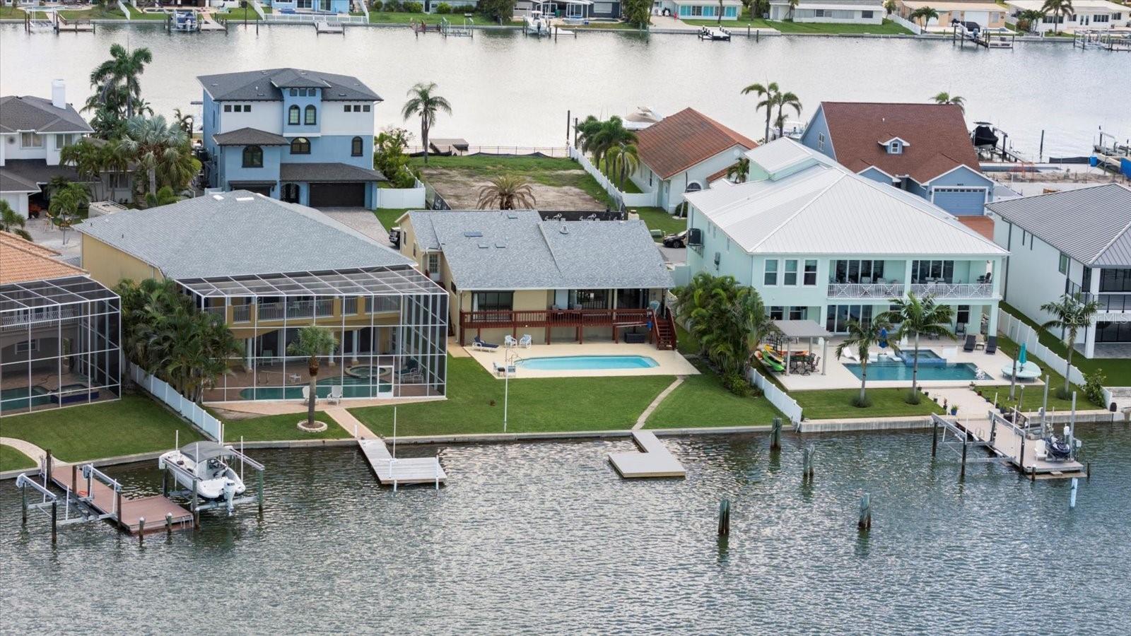 PRICE IMPROVEMENT! Elevated 4-bedroom, 2.5-bath, waterfront home, perfectly positioned on Boca Ciega Bay. This location offers DEEP WATER for docking a large boat and an OPEN WATER VIEW — all just a 5 MINUTE WALK TO THE BEACH!
Set on a deep-water harbor the property features a NEW COMPOSITE DOCK (2025) with a deep water slip that is ready to accommodate your vessel. A 50’ cruiser was kept by the previous owner in the on site slip. There is plenty of room to add a boat lift if desired. The water in the inlet is calm & offers the perfect opportunity to step out on a paddle board or kayak. One of the standout features of this property is its private SWIMMING POOL. Surrounded by a generous concrete deck and a LARGE YARD it offers the perfect space for entertaining or relaxing by the water. The pool area has a beautiful view of the bay and offers a true Florida outdoor living experience, all in the privacy of your own large backyard.
The home's ELEVATED CONSTRUCTION provides peace of mind, storm protection, and REDUCED FLOOD INSURANCE PREMIUMS. A NEW ROOF was installed in 2021, and the structure itself is solid & offers a strong foundation for any future renovations. Inside, the home has a spacious and functional SPLIT PLAN layout with four bedrooms and two-and-a-half baths. The living space boasts a large living room with a stunning stone fireplace, vaulted ceilings & NEW skylights (2021). Designed for a party the dining area is large and open. Also on the main floor is the spacious primary bedroom which features water views, a balcony, his & hers walk in closets & a very large ensuite. The upper level of the home has three bedrooms & a bathroom. Thoughtfully designed, there is a dedicated exit to the pool area on this level. The interior is largely original and ready for your personal touch — a great opportunity to renovate or customize to your style. The floor plan is very well designed & renovations could just be cosmetic adjustments to personalize & update the home.
Located on a quiet street in North Redington Beach, the property is just a short walk from the beach, and minutes from local shops, dining, and entertainment. Whether you’re looking for a full-time residence, vacation home, or investment with long-term upside, this home offers rare deep-water access, protected mooring, wide bay views, a pool, and proximity to the Gulf — all in one of the Gulf Coast’s most desirable neighborhoods. Call for your private showing today!