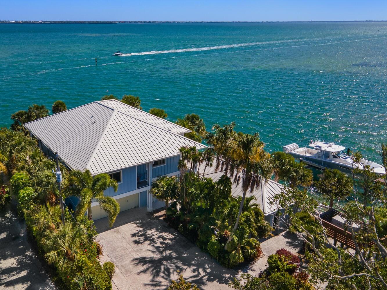 When superior strength meets breathtaking beauty, you have something very special. Welcome to 876 Tarawitt Drive on Longboat Key. This exclusive Bayfront home with separate cottage is a coastal masterwork built to fortress-like standards, offering unparalleled durability, safety and peace of mind in today’s environment. Engineered with all poured concrete, including the re-bar reinforced foundation, the property is also equipped with all Miami-Dade rated hurricane glass, a whole house generator and a corrosion-proof metal roof. These powerful features all contribute to a home that is exceptionally energy efficient, sound-proof and consciously in balance with the natural world. The interior design is nothing short of impeccable, with tongue-in-groove wood ceilings, coastal materials and seaside hues that flow effortlessly from space to space. Brazilian Teak, known for being one of the most durable woods on the planet, is the material of choice for the splendid outdoor decks overlooking miles and miles of glistening Bay waters. Significant investments in custom features, appliances and materials were made in both the main home and the cottage, with absolutely no detail overlooked. In short, this is a legacy home built to weather any storm, and to last for generations to come. Stretching gracefully for about 11 miles on the West Coast of Florida, Longboat Key is a coveted destination for those seeking serenity while still being close to amazing retail, culinary and healthcare amenities. It is the perfect setting for this once-in-a-lifetime property, built with purpose and power, and just waiting for you to discover.