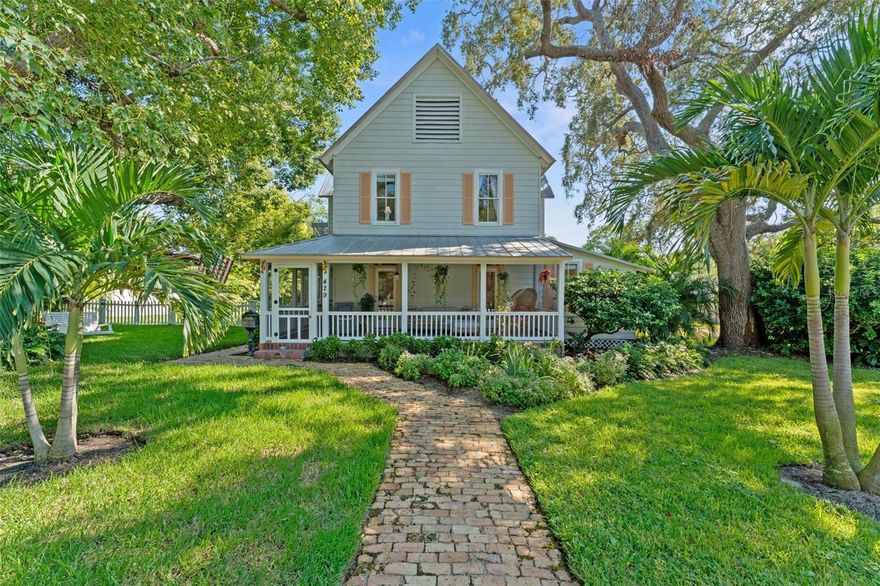 Imagine waking up every day in a home that feels like a storybook come to life. Built in 1900 and beautifully maintained, this iconic VICTORIAN FARMHOUSE sits proudly on a rare DOUBLE LOT totaling a half-acre on one of the most beloved streets in Historic Downtown Dunedin. The home is set back from the sidewalk, giving it a stately presence and a quiet, private feel. From the moment you arrive, the experience begins — the red brick walkway leads past a front yard shaded by beautiful mature trees (complete with a classic tree swing), inviting you to slow down, breathe in, and truly take in your surroundings.

The wraparound screened porch feels like a step back in time, where mornings start with coffee and evenings end with the warm glow of lantern light and conversation. Inside, this home exudes character and charm with pristine original wood flooring, beadboard walls, original brick accents, antique door knobs, and even an antique toilet — saving time by keeping the main bath available for everyone else — all blending seamlessly with modern updates. Three solar tubes fill the interior with abundant natural light, giving the home a warm and airy feel throughout the day.

With 4 bedrooms plus an office (or 5th bedroom), 3 remodeled bathrooms, and a spacious laundry room, this home is as functional as it is enchanting. The custom kitchen is a centerpiece, boasting a copper farmhouse sink, copper bar sink, quartz countertops, neutral cabinetry, pantry, natural gas stove, and newer appliances. The great-room-style kitchen and dining space is perfect for hosting large dinners — just open the French doors to let the party flow to the pool and lanai. Built-in speakers throughout the first floor let you set the mood in every space.

The primary suite offers a peaceful retreat with a walk-in closet and a spa-like bath featuring a custom antique vanity, glass shower, and private water closet. Additional bedrooms are generous and light-filled, with a second bath offering dual pedestal sinks to match the home’s timeless aesthetic.

This property has been thoughtfully updated with a newer dual-zone AC system with gas heat, upgraded electrical, hardwired smoke detectors, aluminum & Hardie board siding, vinyl fencing, pavers, and custom wood blinds — offering the best of both worlds: historical charm with today’s peace of mind.

Out back, the magic continues with a screened-in pool and covered lanai with red brick pavers, surrounded by an extremely private fenced yard — an oasis in the heart of Downtown. There’s also a large outdoor closet for storage. The detached oversized 2-car garage was built to support a second story, making it ideal for a future guest suite, art studio, or office. There’s plenty of space for boats, RVs, and golf carts. Zoned MF 7.5, this property even allows for a conditional-use bed-and-breakfast (contact the City of Dunedin for details).

Best of all, you’re right in the heart of everything — close enough to enjoy Douglas Street parades, with Tukro Coffee just around the corner, yet tucked away enough to feel secluded and peaceful. A short stroll or golf cart ride takes you to Downtown Dunedin’s shops, restaurants, breweries, festivals, and the Pinellas Trail.

This isn’t just a home — it’s an experience, a lifestyle, and a rare opportunity to own a piece of Dunedin’s history on one of the most special lots in town.