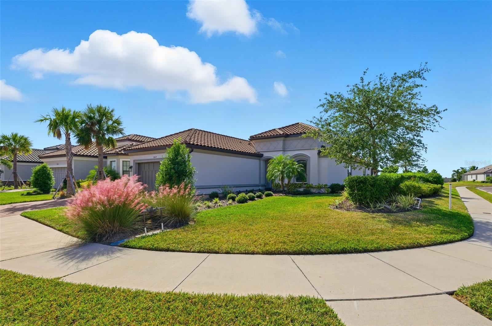 Experience the best of Florida living in this no-flood, no-evacuation zone luxury residence located in the exclusive gated community of Esplanade at Artisan Lakes. This stunning 3-bedroom, 3.5-bath home—with a private office/den or formal dining room—sits on a premium waterfront corner lot, offering exceptional privacy and spectacular sunset views. Designed for both elegance and everyday comfort, this model-quality home showcases high-end upgrades throughout, from tray ceilings and decorative moldings to custom lighting, wainscoting, and upgraded tile flooring. The open-concept layout creates an expansive, airy atmosphere that’s perfect for entertaining or relaxing in style. The gourmet kitchen is a chef’s dream, featuring quartz countertops, 42" upgraded wood cabinetry, built-in stainless steel appliances, and abundant storage. Step outside to your own private backyard oasis, where you’ll find a solar-heated pool and spa, a custom outdoor kitchen, gas fireplace lounge area, travertine-paved lanai, outdoor dining space, and motorized retractable shades—ideal for year-round indoor-outdoor living. The tandem 3-car garage offers additional flexibility for a workshop, golf cart, or recreational storage. The tandem 3-car garage offers added flexibility for a workshop, golf cart, or recreational storage. Beyond your doorstep, enjoy a vibrant, resort-inspired lifestyle with world-class amenities including two luxurious amenity centers with resort-style pools and spas, pickleball and tennis courts, a state-of-the-art fitness center, and a full calendar of social events and activities. The all-inclusive HOA covers lawn care, cable, internet, and more—providing truly effortless, maintenance-free living. Perfectly located just minutes from Tampa, St. Petersburg, Sarasota, and the Gulf Coast beaches, this move-in-ready gem delivers the ultimate Florida lifestyle upgrade.