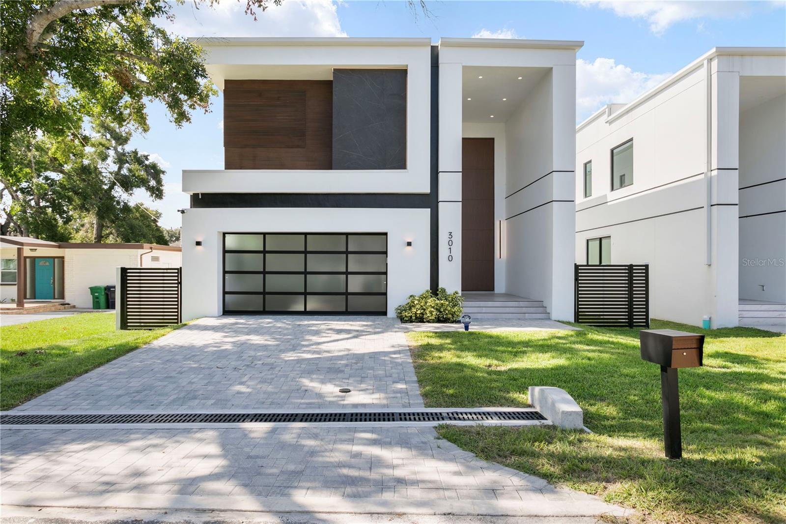 Discover a stunning contemporary residence offering an exceptional combination of cutting-edge design, energy efficiency, and luxurious finishes in this newly constructed two-story home. The property, developed by Arjen Homes, contains approx 3,600 sq. ft. of living space, featuring 4 bedrooms, 4.5 bathrooms, and an open layout designed for both comfort and sophistication. The exterior showcases a sleek smooth stucco finish accented with brick veneer and wood cladding, creating a striking modern façade, while the solid block construction and TPO roof system with R-11 insulated foam boards ensure superior durability and performance. Custom ES aluminum-framed windows with tempered glass and low-E coating add energy efficiency and elegance. Step inside through the massive 20’ pivot-style front door to an expansive open floor plan with 11’6” ceilings, a floating staircase, and imported large-format porcelain tile flooring that seamlessly connects indoor and outdoor living spaces. The chef-inspired kitchen boasts sleek flat-panel cabinetry, premium finishes, and a dining area filled with natural light from oversized picture windows, while the living space includes linear AC vents, stealth acoustics speakers, and integrated smart wiring. The luxurious primary suite offers a spa-style bathroom with floating vanities, frameless glass shower, and soaking tub, complemented by floor-to-ceiling designer tilework. Interior details include 8-foot solid wood doors with Emtek hardware, a powder bath with resort-style finishes, and modern accents throughout. Additional highlights include pre-wired security cameras for 360° coverage, two Navien tankless water heaters with recirculating system, natural gas connections, underground electric service with dual panels, and a 60” Halo 5 water softener system. Located in the heart of South Tampa near Bayshore Boulevard, Ballast Point Park, and Tampa Yacht & Country Club, this home delivers the perfect blend of modern elegance, efficiency, and convenience in one of Tampa’s most desirable neighborhoods. Schedule your private tour today and unlock the door to this exceptional opportunity!