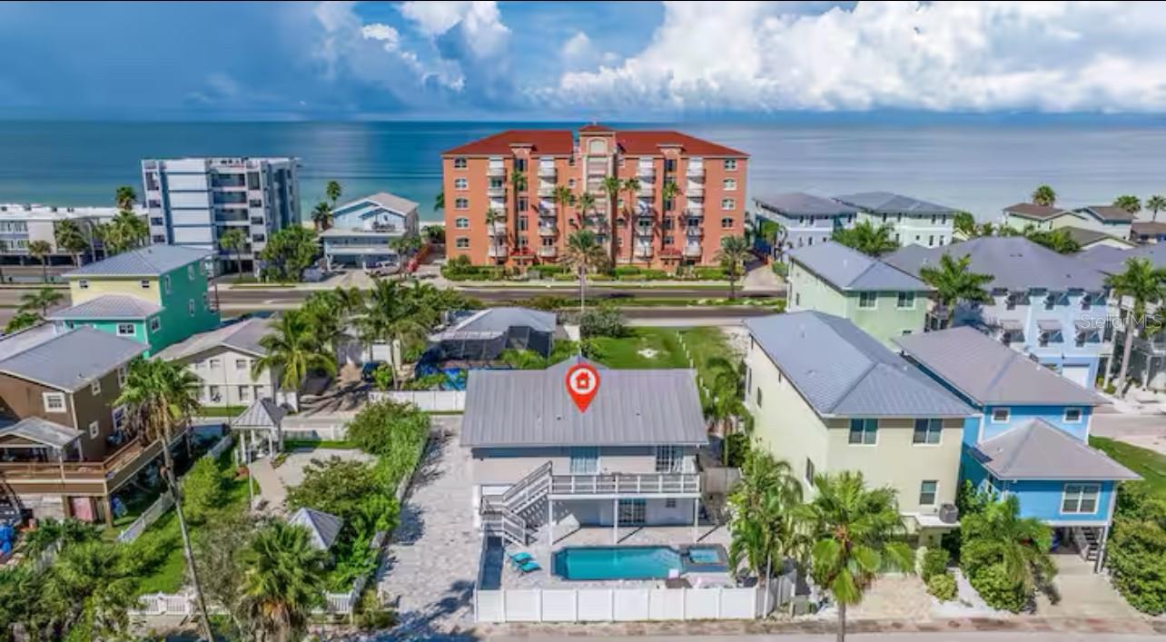 Welcome to your new beach oasis! As an established vacation rental, this beautiful 3 bedroom/2 bathroom home can accommodate up to 11 guests, making it the perfect investment opportunity. With just a short walk to the pristine Indian Shores Beach, and a private crystal clear heated pool and hot tub, this is THE perfect Florida home. As you walk inside, you'll notice the fully updated open living room/dining room and kitchen, perfect for gathering with guests to enjoy dinner, a movie, or game night. You will instantly feel the warmth as natural light pours through the large sliding doors leading out to the front porch. The spacious covered front porch is a great place to enjoy a cup of coffee in the early mornings and catch the famous Florida sunsets in the evenings. Relax and reset in the primary bedroom with sliding glass doors leading to the pool and an ensuite primary bathroom with a large tiled step-in shower. The 2 additional bedrooms and bathroom offer convenience, and the perfect amount of space to decompress without feeling crowded. Whether you choose to make this your full time beach home, or create the perfect vacation rental for guests, this property checks all of the boxes. There is plenty of parking and a large 1st floor garage, perfect for extra cars, storage or even a game room. Don't miss out on this income producing Island gem!