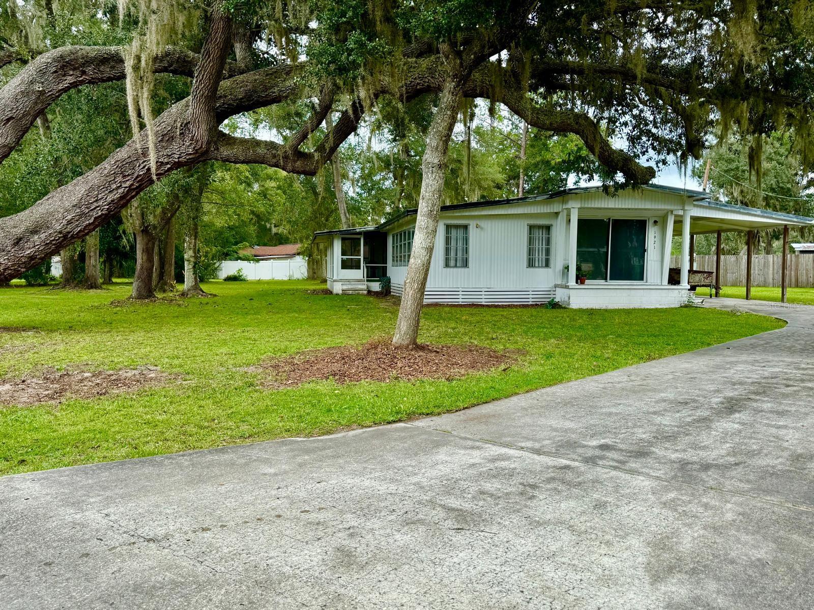 Fixer-Upper Opportunity in Silver Lake Acres with Lake Access! This 3-bedroom, 2-bath mobile home offers endless potential for the right buyer. Situated on a double lot shaded by majestic granddaddy oaks, the property provides plenty of space and charm. The home features a screened-in porch, a large family room, and a sizable block construction building perfect for a workshop or She-Shed! All this is just one block from the lake. This is a small, friendly neighborhood where residents enjoy a welcoming atmosphere, with neighbor-led clubs and access to a community boat ramp, making it easy to get out on the water. It's only 3 minutes to a major supermarket, offering both convenience and a peaceful natural setting. The home needs complete renovation, making it an ideal project for investors or anyone looking to create a personalized retreat. It’s a great option for families seeking a peaceful lifestyle or snowbirds wanting a seasonal getaway in the Ocala National Forest.