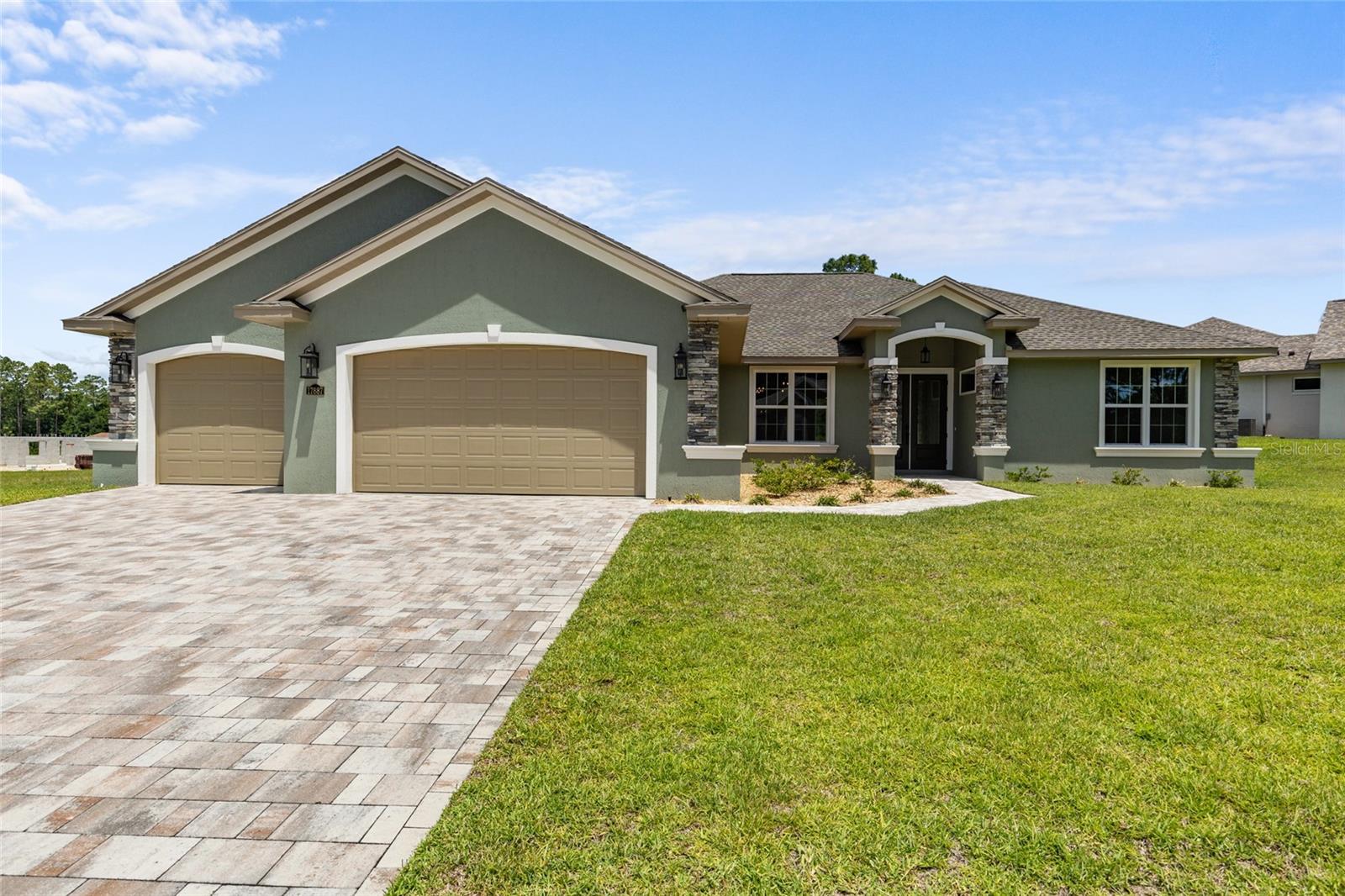 Welcome to a gorgeous custom built 4/3 home in Juliette Falls - a gated championship golf course community! Owner financing available*!! Step through beautiful rain-glass double entry doors into a massive common area with soaring vaulted ceilings, LVP flooring throughout, a modern linear fireplace, and a three panel pocket sliding door. The upgraded chef’s kitchen features custom wood cabinetry, a walk in pantry, an huge elevated island with surround storage , and a full wet bar with beverage fridge. The split floor plan ensures privacy in the primary wing which boasts a spa like bathroom with two vanities, a full tile shower with two shower systems, two walk in closets, and a king sized bedroom with raised ceilings and a door leading to the covered lanai. Across the home, you’ll find 3 additional bedrooms, all with adjoining full bathrooms and step-in tile showers. The oversized laundry / mud room leads to the massive 3 car garage with an expansive paver driveway. The oversized lanai has plenty of space for entertaining, along with a Master Spa therapeutic tub, ready for your enjoyment! An irrigation well tends to the landscaping There are truly too many upgrades to list. Property is located in a great location, perfect for golfers and horse enthusiasts; close to the World Equestrian Center and Rainbow Springs.