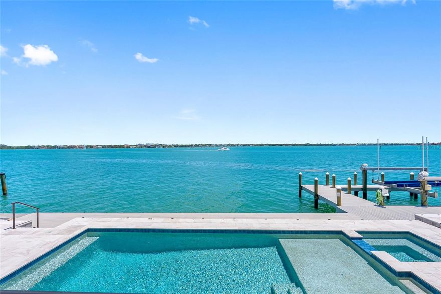 Located on Bird Key, a gated community, one of the most sought-after island addresses in Sarasota, this exceptional custom-built French Country Style waterfront estate, built in 2021, offers the ultimate in luxury coastal living. 
The location is perfect, between Downtown Sarasota, St. Armands Circle, and Lido Key Beach, this amazing residence sits on 135 feet of premier Sarasota Bay frontage with breathtaking wide-open water views and stunning city skyline vistas. This home features an abundance of natural light in every room.
Designed for both elegance and functionality, this home offers 5 spacious en-suite bedrooms, including a luxurious first-floor primary suite with a spa-inspired bath. 
Deep boating waters with no bridges to the Gulf make this property a dream for boating enthusiasts, complete with a private dock and a 24,000-pound boat lift. Outdoor living is elevated with a large, heated saltwater pool featuring a tanning deck, umbrella holder, spa, and expansive entertaining areas. 
Multiple oversized patios on each floor, a rooftop deck/crow’s nest, and a fully equipped outdoor kitchen with a poolside half bath accessible from both inside and outside create the ideal setting for entertaining and enjoying spectacular sunsets over Sarasota Bay. 
Inside, sophistication continues with a formal dining room, private office, expansive game / entertainment room with guest bath, and a beautifully finished elevator with rich wood paneling and tile flooring and a kitchen that is every chef’s dream, Wolf appliances, Subzero fridge, 2 dishwashers, granite countertops and breakfast nook. 
Additional luxury features include hurricane-rated 8 foot windows and doors, generator, 3-car garage with Tesla EV charging station, and high-end finishes throughout. 
Residents of Bird Key enjoy an exclusive private island lifestyle with deep-water canals, bayfront estates, the renowned Bird Key Yacht Club, and quick access to world-class dining, shopping, arts, golf, tennis, and the renowned The John and Mable Ringling Museum of Art, and award winning white sandy beaches. Bird Key and Sarasota have long attracted high-profile residents including Brian Johnson, Jerry Springer, Martina Navratilova, Lucille Ball, Stephen King, Joe Perry, Dick Vitale Bird Key is more than an address—it is a statement of prestige, privacy, and paradise. Call today for your private showing.