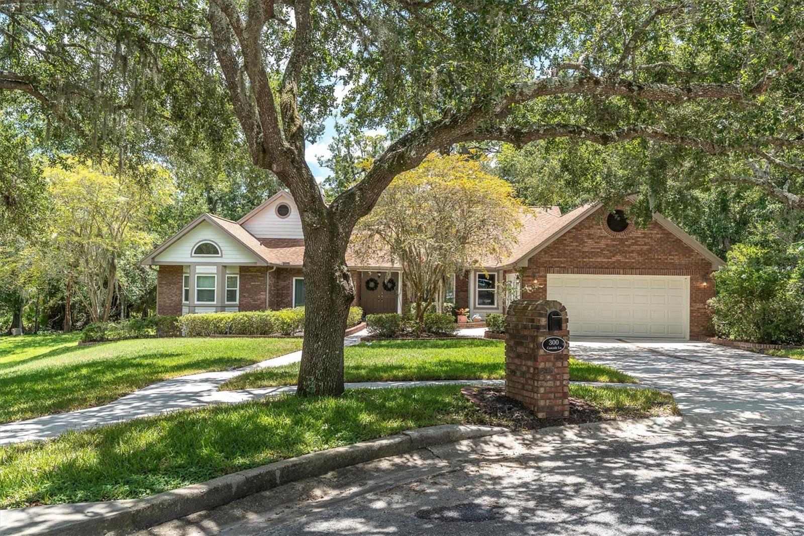 PRISTINE POOL HOME IN DESIRABLE PALM HARBOR LOCATION ON CONSERVATION. Nestled on a shady cul de sac with a park-like feel is your PRIVATE one story mid-century modern inspired ranch style home spanning 2,414 SF offering 4brs, 2 baths and 2 car garage on .45 ACRE LOT zoned for top schools including East Lake High School in the small, quiet community of Woodland Hills. Noteworthy upgrades include: NEW HURRICANE IMPACT WINDOWS 2025, Fresh interior Sherwin Williams Alabaster paint, Engineered hardwood floors, REMODLED KITCHEN IN 2022, 2 WOOD BURNING FIREPLACES and custom lighting. The attractive exterior will impress featuring stacked brick, siding, 30yr 3dimensional shingle roof 2018, and lush, manicured landscaping enhances the curb appeal. As you enter, 18-foot ceilings give an elevated feel as you take in the character of this modern masterpiece. A formal living room captures your attention centered on a cozy wood burning fireplace, glass décor shelves and sliders and an arched window frame the pool & views beckoning family to rest and enjoy time together. A formal dining room is illuminated by chandelier & window overlooking pond with fountain. The charming family room is anchored by a striking wood burning fireplace surrounded by marble with wood accents, built in glass shelves and large windows + sliders frame the nature views. A banquette seating bench with storage is bathed in natural light from the 3 windows that surround this casual café dining space. With no shortage of seating, a breakfast bar also seats 4 barstools. The newly remodeled kitchen features an abundance of cabinet & drawer space, sparkling granite countertops, under-cabinet lighting, and newer smudge proof stainless steel appliances. Storage is abundant with a large pantry which also leads to an indoor utility room. The primary suite is a tranquil retreat, featuring VAULTED CEILINGS, built in bookcase, framed mirrored wall, walk-in closet, and sliding doors opening to the pool area. The primary ensuite features cherry wood cabinets, granite counters, ceramic pedestal sinks, a walk-in shower and spa jacuzzi bathtub. Br 2, located adjacent to the primary, provides view of the fountain & custom built in closet, could be used as a br or office. This split floor plan provides 2 additional spacious bedrooms and another full bath off the kitchen. Relax on your screened lanai with coffee or make a splash in the oversized pool overlooking the peaceful conservation views. If privacy is a priority, this home is for you! A backyard draped in trees warps around the house expanding to the pond with soothing fountain. The high quality sod is both shade tolerant and drought resistant which ensures a lush and inviting lawn. Enjoy regular daily sightings of deer, birds, ducks, owls and hummingbirds that are drawn to the beautiful array of flowers and plants. There are over 50+ azaleas in the front of the property alone. NO FLOOD ZONE. LOW HOA includes community pool, playground, tennis & pickleball courts! *Tankless hot water heater* Security system* This prime location provides close proximity to TPA airport, top-tier hospitals, close to Caladesi and Honeymoon Island, shopping and Restaurants. Zoned for Top Rated Schools. Make this modern beauty your today.