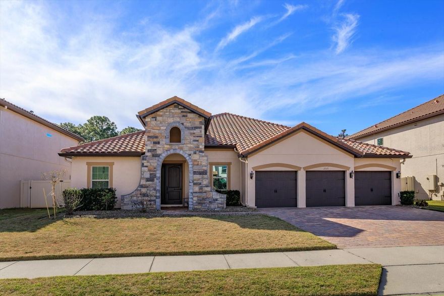 Situated on a quiet cul-de-sac within the intimate, gated neighborhood of Ellingsworth, this stunning 4-bedroom, 3-bath + office Spanish Mediterranean residence offers 3,000+ square feet of thoughtfully designed living space in one of Oviedo’s most desirable settings, just moments from the Econlockhatchee Conservation Area. Set on a spacious .25-acre lot backing up to peaceful wooded views, the home’s  architecture makes an immediate impression with stone accents on the facade, a long lasting tile roof, brick paver driveway, and oversized 3-car garage.

Inside, fresh interior paint complements an open, light-filled floor plan designed for both entertaining and everyday comfort. A combined living and dining room welcomes you at the entry, while the separate family room flows seamlessly into the expansive kitchen. Anchored by granite countertops and a center island, the kitchen features a breakfast bar with seating for four, built-in convection oven, glass cooktop with vent hood, and newer appliances including a 2025 Bosch dishwasher and French-door LG refrigerator with craft ice. New paint, lighting and ceiling fans throughout enhance the home’s modern feel.

The primary bedroom serves as a private retreat with a spacious bath that includes dual vanities, an oversized soaking tub, separate shower, and a generously sized walk-in closet. Three additional bedrooms and well-appointed baths provide flexibility for family and guests, including a convenient pool bath. Step outside to your screened-in pool and spa, where the fully fenced backyard offers privacy and room to enjoy Florida living at its finest. Exterior updates include new paint, fresh sod, new gutters and a recently installed French drain system. Additional features of the home include attic foam insulation, built-in garage storage racks plus a newer LG large-capacity washer and dryer that convey with the purchase.
This home offers the perfect balance of privacy and convenience. Located just minutes from the zoned schools, only two miles to UCF, and close to major transportation corridors, shopping, and dining, this home really has it all! Please schedule your private showing today!