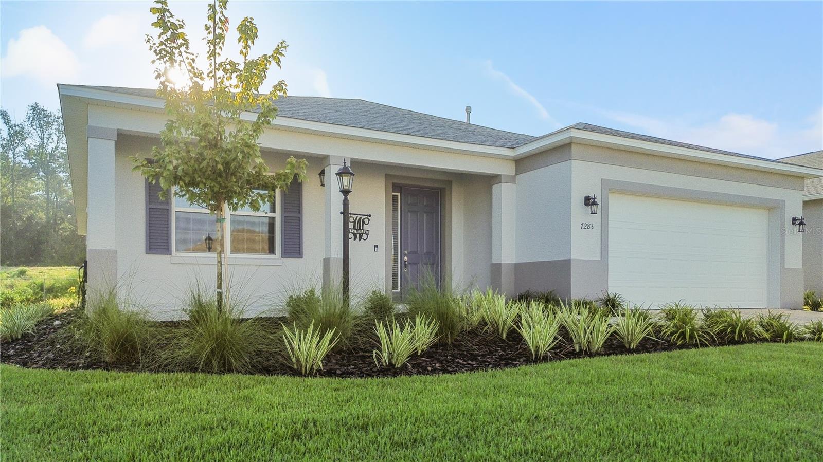 Built in 2025 with upgrades galore, this Wisteria model is nestled in the new community of Weybourne Landing located within Ocala's premier 55+ 'On Top of the World'. Gated access adds privacy and exclusivity when entering the neighborhood, where you own your own lot (no land lease). Step inside your immaculate and airy Florida home, greeted in the foyer. The open-concept floor plan allows for full-home views of a stately and functional kitchen and great room living space; and the upgraded 24x24 tile flooring runs throughout the entire residence- no carpet to fuss over. The gourmet kitchen is an entertainer's masterpiece with its L-shaped island covered in quartz, soft closing drawers, specialty under-cabinet lighting, and full-sized walk-in pantry. New stainless steel appliances, including a gas cook top makes preparing meals fun and easy; and, the built-in microwave and oven add sleek lines and sophistication in the kitchen. The refrigerator can fit more than you may need, and the Samsung matching washer and dryer appliances convey as well! The primary bedroom suite overlooks the backyard, can easily fit a King-sized bed and end tables, and offers two spacious walk-in closets for perfect organization. The ensuite bathroom adds the 'wow factor' balancing darker solid stone counters and tile. The walk-in shower was thoughtfully designed for wheelchair accessibility. Two more guest bedrooms split between another full bathroom with tub and shower combination creates the perfect space for loved-ones to visit. Enjoy the modern conveniences of Smart technology at home; and grab your favorite beverage and enjoy the sunsets from the covered front porch. Feel secure in parking both your vehicle and golf cart in the two-car garage. Outdoors, the irrigation system keeps the yard looking like perfection, and the back patio offers ample room to lounge or entertain. Weybourne Landing residents enjoy access to an amazing pool, fitness center, pickleball courts, dog park, clubhouse, mini-golf, and an outdoor pavilion with BBQ grills. The monthly HOA includes trash pickup and internet. Utilities include Teco Peoples Gas, Bay Laurel Water, Duke Energy, and Golden Leaf. Ask for a full list of UPGRADES in this one-owner, 2025 build! This property is everything you've dreamt about, chalk full of amenities, within close proximity to hospitals and medical care, great restaurants and entertainment including the Circle Square Cultural Center, and easy shopping outings- cruise by golf cart to your favorite destinations. Add this special home to your list of must-sees; you could be here before it's time to decorate for the holidays!