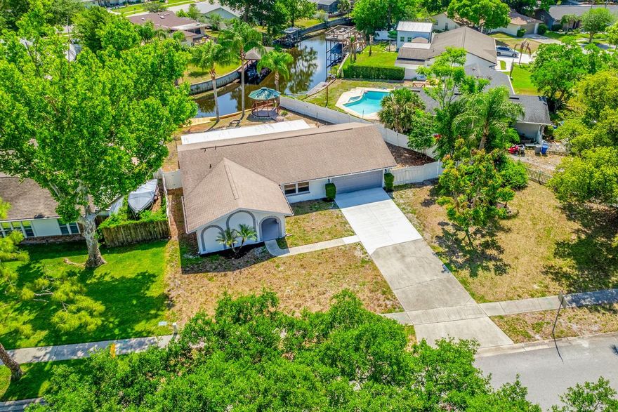 One or more photo(s) has been virtually staged. CANAL FRONT LIVING ~ PRIVATE POOL ~ UPDATED ~ NO HOA! Big-ticket upgrades are already done, and the lifestyle is hard to beat – welcome to your CANAL FRONT ~ POOL HOME in the desirable University Shores area of Orlando with direct access to SKIABLE Lake Irma! Recent improvements include UPDATED ELECTRICAL, NEW LUXURY VINYL PLANK FLOORING, REMODELED KITCHEN & BATHS, NEW WOOD DECK/PRIVATE DOCK, plus a newer WATER HEATER (2023), ROOF (2021), A/C (2018), and double pane windows – giving you peace of mind and a truly MOVE-IN READY experience. Set on a spacious .27 ACRE LOT, this property is all about embracing Florida living. Launch your boat right from your backyard, unwind on the new deck overlooking the water, or enjoy the private pool and expansive SCREENED LANAI with plenty of green space to spread out and entertain. And with NO HOA, you have the freedom to truly make it your own. Inside, a light-filled, flexible layout offers both formal living and dining spaces along with a comfortable family room that flows seamlessly from the kitchen. The updated kitchen is designed for everyday living and entertaining alike, featuring STAINLESS STEEL APPLIANCES, ample cabinet and counter space, a breakfast bar, and a window over the sink overlooking the backyard. A sunny breakfast nook connects it all, creating a welcoming central hub. The split layout provides privacy, with the PRIMARY SUITE perfectly situated at the back of the home to take full advantage of the WATER VIEWS, complete WALK-IN CLOSET and beautifully updated en-suite bath. Two additional bedrooms sit at the front of the home with easy access to a second full bath. A large laundry room with EXTRA STORAGE adds to the functionality of the space. The curb appeal starts with a COVERED FRONT PORCH, while the 2-car garage and generous lot round out the exterior features. Located just minutes from SR 50, 417, and 551, with easy access to Downtown Orlando, Waterford Lakes, shopping, dining, parks, and more, this home delivers both convenience and lifestyle. Whether you are looking for a first home, investment opportunity, or a waterfront retreat, this one checks all the boxes. BRING YOUR BOAT and start living the lake life. Call today to schedule a tour!
