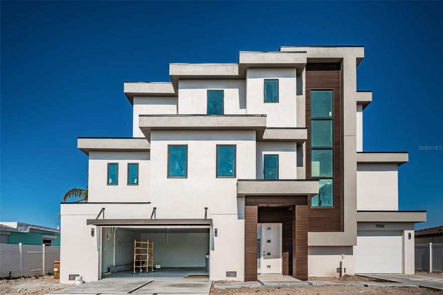 Under Construction. UNDER CONSTRUCTION WITH AN EXPECTED COMPLETION DATE OF LATE APRIL 2026. With rich modern symmetry and beautiful lines throughout, this elegant coastal contemporary waterfront residence enjoys luxurious finishes throughout and gorgeous waterviews. A striking covered entry reveals a massive lower level with epoxy flooring and parking for 6+ vehicles. Tall ceilings, fine wood floors and tall window views give the home an exquisite, inviting appeal. First living level features an inspiring great room plan that opens to a 21ft wide covered balcony overlooking the waterfront (balcony includes a lovely built-in gas cooking center). The splendid living room offers sweeping waterviews, an attractive built-in wetbar and a sizable adjacent waterfront dining area. The sumptuous open concept chef’s kitchen boasts superb quartz surfaces, superior wood cabinetry, high-end stainless steel appliances, a large island dining bar/prep center and a surprisingly-roomy hidden pantry closet. The laundry facility is sizable, with posh quartz surfaces and extensive cabinetry/storage. You’ll appreciate the finishes and detailed tilework in the full guest bathroom. Your impressive owner’s suite overlooks the waterfront and is supported by a fabulous closet system. Step into the dazzling owner’s bath with lavish his/her vanities, stand-alone soaking tub and brilliantly-tiled walk-in glass shower enclosure with dual shower heads. The executive office, with its glass door entry, has a striking minimalistic allure. Upper level contains a large family room and three spacious bedroom suites. Family room opens to an oversized, covered upper-level balcony with commanding views of the waterfront and intracoastal waterway. Two upper-level suites overlook the water, and all three feature luxurious full baths and resplendent closet systems. Step out back and you’ll discover a substantial 56ft-wide covered lower-level deck that transitions to a stunning swimming pool and spa. Covered deck gives ample space for outdoor poolside lounging and dining. Home provides a 3-stop elevator and many value-added extras including a new seawall and new composite dock. This is an exceptional new construction waterfront home close to the beaches and less than a 15-minute drive to downtown St. Petersburg. Dimensions are estimates, buyer to verify.