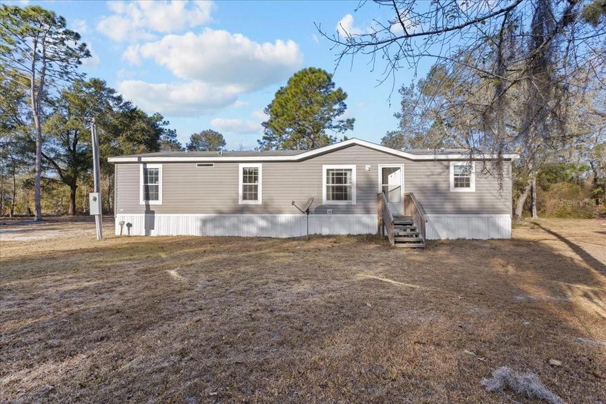 Built in 2018, this home sits on a full 1-acre lot in the quiet, rural area of Williston, Florida, located in Levy County and zoned Agricultural/Rural Residential. Featuring an open floor plan with a comfortable flow between the living area and kitchen. The kitchen is generously sized and includes a large island, plenty of counter space, and storage, making it both functional and inviting. Just off the kitchen is a dedicated indoor laundry room.  The primary bedroom is spacious with a large walk-in closet connects to the primary bathroom, which offers both a walk-in shower and a garden tub. The split floor plan provides separation between the primary suite and the remaining bedrooms, offering added privacy. Outside, the 1-acre property provides room to enjoy country living—whether that means gardening, outdoor projects, or simply enjoying the quiet surroundings. This home offers a solid combination of modern construction, practical layout, and rural setting while still being within a reasonable drive to Williston and nearby conveniences. Just minutes away is Black Prong Equestrian Village, Williston Municipal Airport, close proximity to Devil’s Den Prehistoric Spring and Campground and Blue Grotto Diving Springs, Family-friendly attractions such as Kirby Family Farm and Two Tails Ranch: All About Elephants are also a short drive away. Approximately 30 minutes from both Gainesville and Ocala. Some photos have been digitally staged or enhanced to illustrate potential furniture placement and room use. Actual property condition and features may vary.