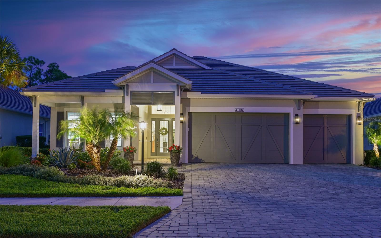 This stunning Outrigger floor plan offers 3 bedrooms, a private den, 2.5 baths, and 2864 square feet of designer living space. From the moment you arrive, the inviting front porch sets the stage for warmth and sophistication found within. Step inside to discover an expansive great room and dining area, highlighted by soaring 12' ceilings, custom built-in shelving and a striking tray ceiling with custom beams. The kitchen is a chef's dream with a six-burner cooktop, convection wall oven & microwave and French door refrigerator. With an extended cabinet and counter area featuring a wine center, along with a large island that comfortably seats four, this kitchen is an entertainer's delight! The spacious primary suite is a true retreat, adorned with luxury vinyl plank flooring and expansive views of the private preserve and lanai. The suite includes a large walk-in closet with custom built-in's and a luxury primary bath featuring dual vanities and a spacious walk-in shower. The two secondary bedrooms with luxury vinyl flooring each have walk-in closets, providing comfort for family and guests. A private den with built-in desk is perfect for a home office or flex room, while the mudroom and laundry room with built-ins add convenience to daily life. A pool bath provides direct outdoor access to the lanai. An expansive covered lanai extends the living space with a full outdoor kitchen with bar seating, custom wood paneled ceiling, and a striking stone fireplace, The centerpiece: a true resort-style pool and 8-person spa, all set against a backdrop of a permanent nature preserve for ultimate beauty and tranquility. Additional highlights include impact windows throughout, pre-wire for a smart security and music system, designer paint and custom trim, a spacious 3-car garage with epoxy finished floors and landscape lighting. Beyond your doorstep, the Lakehouse Cove lifestyle awaits! Enjoy exceptional community amenities featuring a resort-style pool and spa with lake view, community clubhouse, state of the art fitness center, 6 pickleball courts, 2 dog parks, boathouse and kayak launch. This home offers privacy and serenity, while being a short stroll to vibrant Waterside Place, that features an array of restaurants, shopping and community events. This is more than a home - it's a lifestyle!