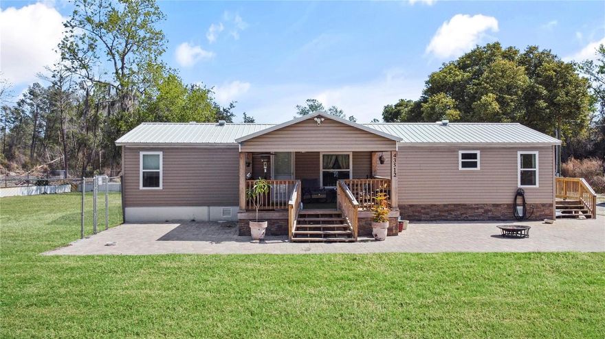 Set on over 3.5 high-and-dry acres, this nearly fully cleared property offers the perfect blend of privacy, functionality, and modern comfort. Ideal for those with recreational vehicles, equipment, or a passion for farming and livestock, this versatile estate delivers the freedom of country living with convenient access to major roadways. The fully updated home has been thoughtfully renovated from top to bottom. Recent upgrades include a new metal roof, new windows, new electrical panel, new plumbing, new A/C system, recessed lighting, new knockdown texture, baseboards, and interior doors. The stunning kitchen features granite countertops, modern finishes, and flows seamlessly into the open-concept living area. Vaulted ceilings and abundant natural light enhance the spacious open and split floor plan. Both bathrooms have been completely renovated, with the primary suite offering a double vanity and a beautifully appointed walk-in shower. An interior laundry room adds everyday convenience. Outdoor features truly set this property apart. A 1,000-square-foot workshop includes a car lift and built-in office — perfect for mechanics, hobbyists, or business use. Two chicken houses are already in place, and the property operates on well and septic with no HOA, giving you flexibility and freedom. For added peace of mind, the home is equipped with a whole-home Olympian generator. Enjoy the serene setting from the brand-new decks at both the front and back of the home — perfect for relaxing or entertaining while overlooking your expansive acreage. This is a rare opportunity to own a move-in-ready home with room to grow, work, and play — all while enjoying privacy and convenience. Call listing agent today for your private showing!