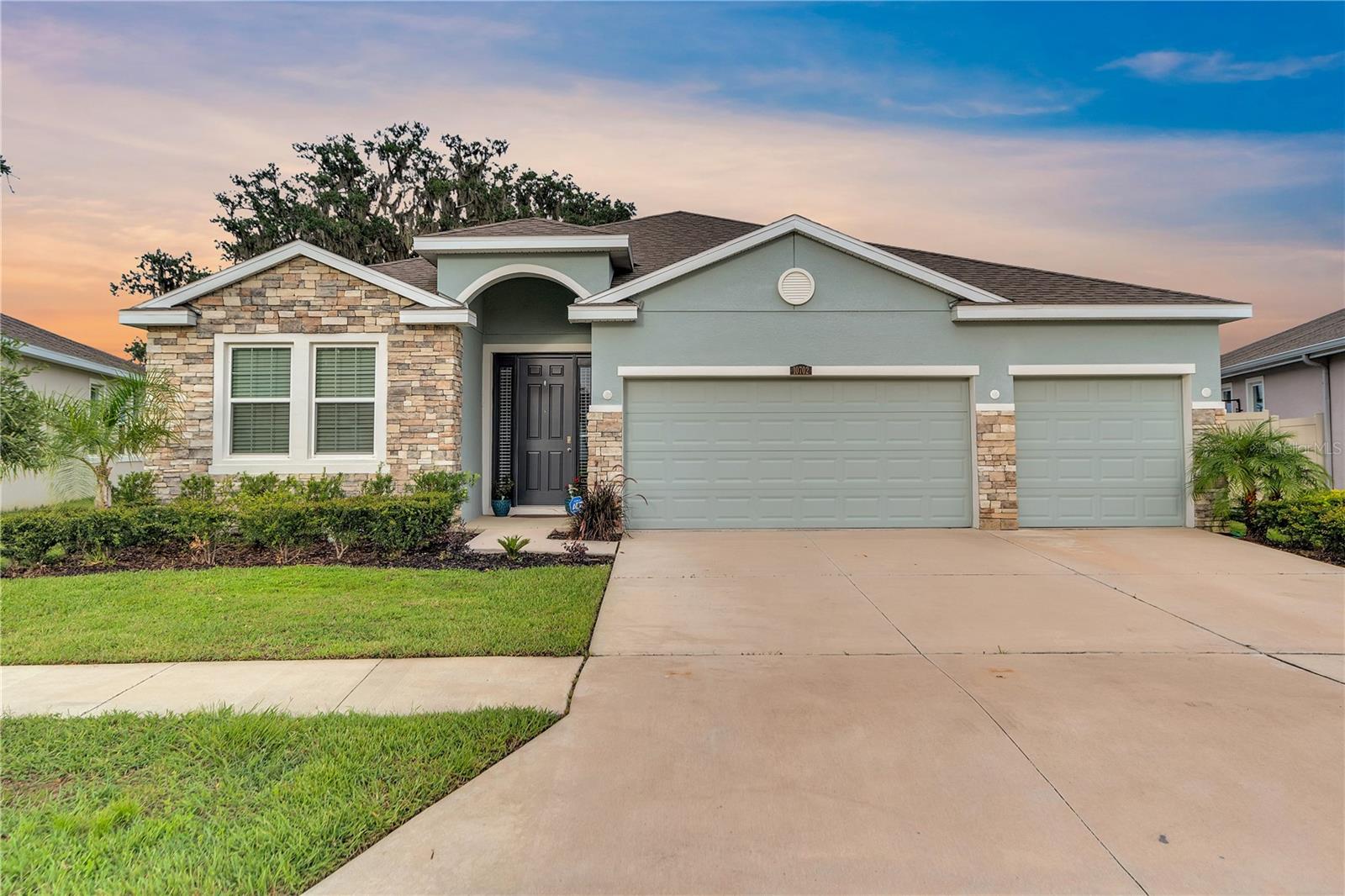 Assumable 2.75 VA loan for eligible buyers. Live every day like a vacation in this exceptional 4-bedroom, 3-bath home on a premium pond-view lot in Mirada, a beautiful community with a spectacular 15-acre Crystal Lagoon—a shimmering blue oasis to kayak, paddleboard, or relax on sandy beaches. Built in 2021, this modern retreat showcases an airy open-concept floor plan with abundant natural light. The kitchen offers granite countertops, a large island, stainless steel appliances, and elegant cabinetry. The spacious primary suite has a walk-in closet and spa-inspired bath with granite counters, plus a second ensuite bedroom ideal for guests or multigenerational living. Two additional bedrooms provide flexibility for work or hobbies. Enjoy the covered patio overlooking the pond and a stunning 100-year-old oak tree. A three-car garage adds everyday convenience. Mirada includes ultra-fast Wi-Fi, cable TV, and resort amenities like a swim-up bar, on-water obstacle course, walking trails, playground, dog park, and beautiful scenery. Minutes to I-75, shopping, dining, and Tampa attractions.
