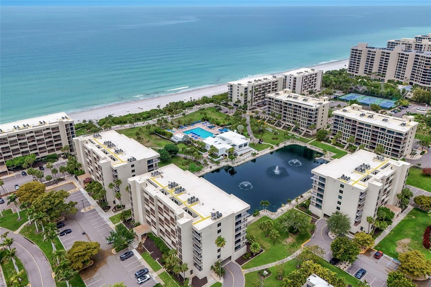 A rare private walk-down residence in the highly sought-after Beachplace community on Longboat Key. This property offers the convenience of direct terrace access to the beautifully landscaped grounds below, overlooking a serene pond with fountains and offering a charming peekaboo view of the Gulf. Spacious and largely original, presenting the perfect canvas for a buyer to customize and create their ideal coastal retreat while enjoying the exceptional location and layout. The light-filled interior features an open living and dining area with walls of glass that connect seamlessly to the outdoor living space, creating an inviting indoor-outdoor lifestyle just moments from the beach. The split-bedroom floor plan offers privacy and functionality, while the terrace provides a peaceful setting to relax and enjoy the lush tropical surroundings. Whether updating immediately or renovating over time, this residence offers tremendous potential within one of Longboat Key’s premier Gulf-front communities. Beachplace is renowned for its resort-style amenities and beautifully maintained grounds. Residents enjoy 24-hour guard-gated entry, on-site management, a clubhouse, fitness center, tennis and pickleball courts, heated swimming pool and spa, private beach access, walking paths, and expansive tropical landscaping throughout the community. Ideally positioned on the south end of Longboat Key, Beachplace is just minutes from the fine dining, boutiques, and waterfront charm of St. Armands Circle, as well as downtown Sarasota’s cultural attractions, marinas, golf clubs, and world-class beaches.
Whether you are searching for a seasonal getaway, investment opportunity, or full-time coastal residence, this property presents exceptional value and the opportunity to create a personalized beachfront retreat in one of Longboat Key’s most desirable locations.