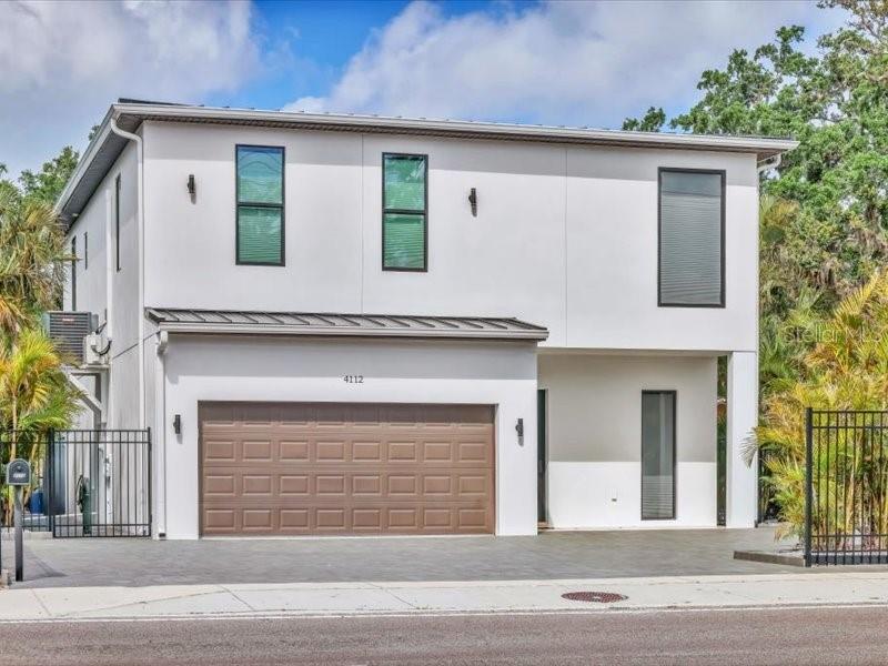 Location, location, location! This contemporary gem is just minutes from Siesta Key beach and downtown Sarasota. This custom home with brand new standing seam metal roof was built with detail in mind. The first floor offers a beautiful open floor plan feature living, dining and custom kitchen. The kitchen stuns with quartz counter tops, stainless steel appliances and large cooking island. The first floor also includes a guest bedroom, guest bathroom and laundry room. Take the lovely staircase up to your second floor. Here you will find a split floor plan with two bedrooms and a bathroom as well as the primary bedroom and bathroom. The second floor also features an additional large living room great for entertaining or relaxing. The primary bedroom has two walk in closets, a large newly renovated primary bathroom with free stand tub and shower with rain head. Also, this house features automatic shades throughout, hurricane windows, spray foam insulation for energy and cost savings. Garage floor has new epoxy and pavers have new sealer. Some photos have been digitally staged.