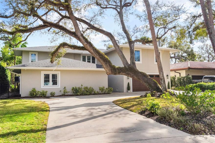 This stunning contemporary was completely TRANSFORMED in 2019 into the ideal entertaining home. The renovation included a new roof, impact rated windows, HVAC systems, plumbing and more!  Tucked away beyond the circular drive on an oversized lot, this beauty does not appear to be 5,621sf, but prepare to be impressed! As you approach the double door entry, note the exterior foyer lending itself to a special welcome for visitors throughout the seasons. Upon entering, take a moment to appreciate the abundance of natural light . Your eyes will be drawn to the wall of windows with views of the expansive back yard and canal. The family room offers space to mingle. Select your favorite bottle of wine from the temperature-controlled display and play a round of pool or relax by the fire. The dining room can accommodate a large dinner party. Guests can also sit and mingle with the chef at the large island. The kitchen features solid quartz counters, a six-burner gas cook top, double oven with speed cook and convection features and ample storage including a walk-in pantry. The French doors lead to a covered patio and outdoor grill with bar seating. Or open the wall of sliders off the family room to the outdoor sitting area. This is where you will want to gather! Imagine the events you can host on the pavered patio spanning over to the sprawling 16x32 feet pool. It's the perfect place to take a dip after a day on the boat. The covered dock offers a 10,000LB BOAT LIFT and an additional DUAL JET-SKI LIFT. Another unique feature is the 528sf of added deck that is grandfathered on to the property. Back inside, past the powder bath, find a FIRST-FLOOR PRIMARY suite with two walk-in closets. The bath features a dual sink vanity, freestanding tub, and walk in shower. Upstairs features three more secondary bedrooms each with their own baths. The fifth bedroom is a sizable IN-LAW SUITE. It is connected to a spacious media room by a kitchenette. Or guests can enter via the back staircase that leads to the mudroom off the garage. Other features include a Control4 home system, an invisible pet fence, EV Charging outlet, whole house filtration and water softener system, closet shelving systems, exterior cameras, updated electrical, mosquito mist system, plumbing, HVACS, roof and more! Thanks to its location, you have easy access to Tampa International, St Pete, downtown Tampa and more! It is also zoned for A rated schools (Plant High School). There are some established neighborhoods that embody what makes south Tampa special. Sidewalks for strolling and visiting neighbors, deep canals leading to the open bay, and spacious lots with mature landscaping providing privacy and serene settings. BEACH PARK is such a place. And 5018 S THE RIVIERA is in the heart of it all!