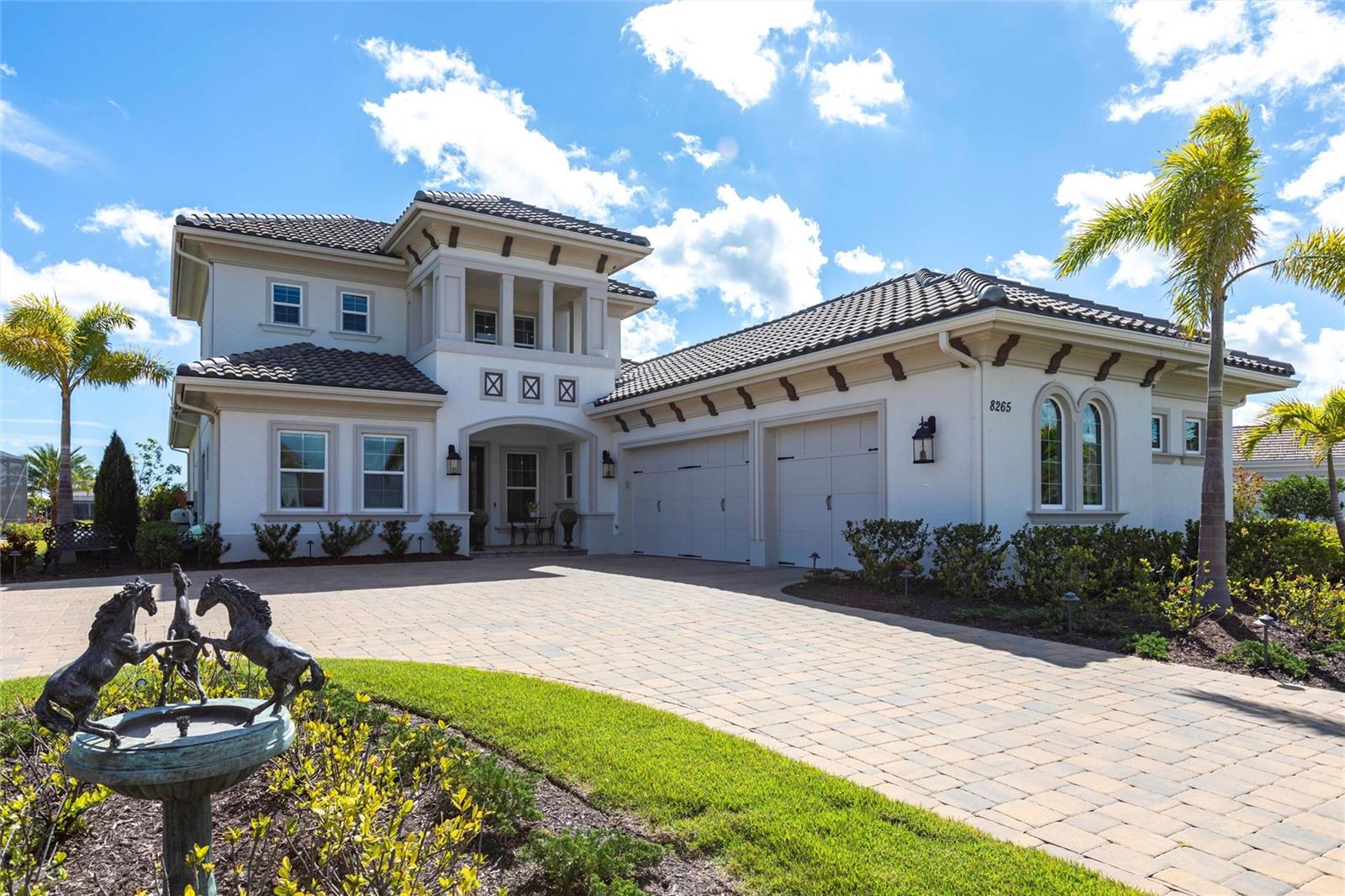 MOTIVATED SELLER! Ask about customizations and upgrade credits offered by seller at closing. Pre-paid HOA for 2025. Luxurious Lakefront Living in The Lake Club. Welcome to an extraordinary blend of elegance and comfort in this spectacular two-story waterfront home. Offering over 3,700 square feet of luxurious living space, this Mayfield Grande III model impresses with thoughtful design, breathtaking views, and top-tier finishes. A garage with 3 1/2 spaces! Five-bedrooms, four-and-a-half-baths, and an extraordinary upstairs layout. From the moment you enter, you're greeted by unobstructed lake views and a light, neutral color palette that sets a serene tone throughout, with oversized porcelain tiles. The open and versatile floor plan allows for a seamless flow between the great room, gourmet kitchen, and dinette areas, making entertaining a breeze. The great room is a showstopper with custom-built shelving, a modern horizontal gas fireplace, and fully pocketing sliders that blur the line between indoor and outdoor living. The gourmet kitchen features extensive cabinetry, JennAir appliances including a warming drawer and five-burner gas cooktop, plus a generous oversized island for gatherings and meal prep. Step outside to your private oasis with 65 feet of lake frontage framed by a panoramic screen enclosure. The travertine-paved lanai features a heated saltwater pool and spa with LED lighting, water features, sun shelf, and in-pool lounge chairs. Enjoy the outdoor kitchen equipped with a grill, sink, bar fridge, and built-in sound system, or cozy up by the outdoor gas fireplace for year-round relaxation. The primary suite is a true retreat with French doors to the lanai, dual walk-in closets, and a spa-like bathroom boasting double vanities, an oversized walk-in shower, and a freestanding soaking tub. Two generously sized guest bedrooms on the main level share a Jack-and-Jill bath, while a fourth bedroom enjoys a private en-suite. A glass French-doored office/den with a closet adds flexibility as a sixth bedroom or study. Upstairs, an enormous bonus room is pre-wired for use as a media or game room and features its own gas fireplace, wet bar with beverage fridge, and an additional guest bedroom with an en-suite bath, complete with a disappearing TV for added luxury and privacy. Additional highlights include: impact-rated hurricane windows and doors, oversized three-car garage with epoxy flooring, large functional laundry room with ample storage, grand circular paver driveway. This exceptional home offers resort-style living in one of the area’s most coveted communities - The Lake Club. Schedule your private tour today and experience the very best that Lakewood Ranch has to offer. P.S. Be sure to check-out the interactive virtual tour attached to this listing.