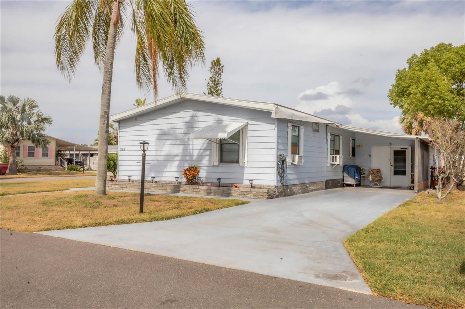 Seller is offering a $8000 sellers credit to fix the carport. Welcome to your own little peace of paradise.This spacious corner lot backs up to a beautiful little lake. This is one of the few three bedroom homes in Shadow Brook. This move in ready home is waiting for you to make it your own. Shadow Brook is one of the best kept secrets in Manatee county. You own the land which means NO LOT RENT. The low quarterly fee includes Water, Sewer, Cable and Internet. It is a any age pet friendly park. It features a new AC installed June of 2024. It also features A new roof installed on 10/24/2023 and has a lifetime warranty. This home has also has had the hurricane straps brought up to today standards. Over $5000 spent on it. It has passed a engineering report. It has a huge shed with tons of storage space. Shadow Brook features a beautiful heated pool and shuffle board courts. The clubhouse has a large library and a pool table. You can rent out the clubhouse for special events. Shadow Brook is located near the Sunshine Skyway Bridge and I 75. The beautiful gulf beaches of Anna Maria Island are just a short drive away. All room sizes are approximate. Please use As Is contract.