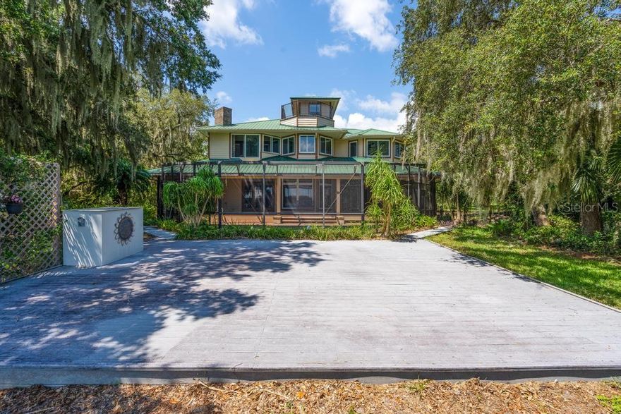 Original owners offer this beautiful property close enough to downtown but a million miles away from urban development in the environmentally protected Green Swamp area of a birder's paradise. Natural beauty awaits you in this secluded, waterfront retreat offering 10.5 acres and the perfect floor plan for a multi-generational family.  The property offers plenty of space for additional structures like an in-law house, horse barn, or other secondary structures.  With 2 docks, you'll view sunrise over Lake Gary, a private lake perfect for the avid water-skier,  and sunset over the pond. Shaded with pine, palm, oak, and cypress trees the private drive leads you to a screened, wrap-around porch overlooking wooded land, lake frontage, and fruit orchards.  Entering the foyer your eye is drawn through the home out to the lake.  The large gourmet kitchen offers granite counter tops, 42" cabinetry, appliance garages, a walk-in pantry, an island, plenty of storage and the solar hot water heater makes clean up easy.  Warm up in the living room with the wood burning fireplace and feel the togetherness that comes from the open floor plan.  The first floor master suite offers french doors onto the pool deck and a walk-in tub in the bathroom -- perfect as an in-law suite.  The first floor layout makes this home perfect for a multi-generational family or a home to age in place. The large laundry room downstairs is outfitted with cabinetry for storage, a laundry sink, and an outside entrance beside the outdoor shower.  Upstairs the landing is a perfect place to get away for lake views and is the entryway to 2 additional master bedrooms.  The large master suite offers a balcony on each side of the bedroom, a gorgeous wooden ceiling, a built-in closet system, and the bathroom offers jetted tub, a stand up shower, a water closet  complete with a bidet.  The second master bedroom on the second floor offers a walk in closet, a window day-bed with cedar-lined interior for storage, and it's own en-suite bath.  Plantation shutters adorn the windows peering out over the property revealing a pole barn that stores equipment, walking trails have been cut through the woods, fruit trees are bearing fruit, and fish jump in the lake.  Go up one more flight of stairs to the crow's nest on top of the home for views of the treetops, a long distance view across the lake, and the perfect place to view the stars at night.  Heading out of the home there is a large storage room between the laundry room and large 2-car garage. Enjoy fresh produce from your own fruit tree orchard with citrus and other edibles! For information on the water quality of this beautiful, pollution-free 96 acre lake go to: https://lake.wateratlas.usf.edu/waterbodies/lakes/7991/lake-gary