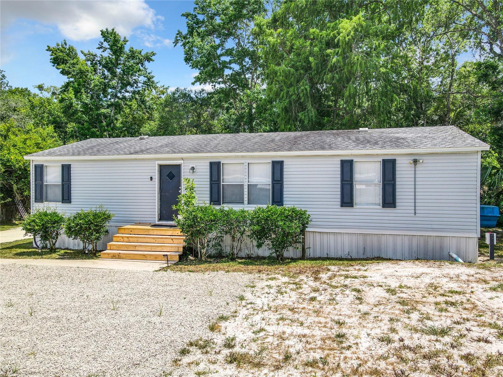 Welcome to your waterfront paradise! This charming partially furnished 3 bedroom 2 bathroom home is nestled along a freshwater canal, offering serene views, including an impressive fountain. The back porch/deck is perfect for enjoying your morning coffee or hosting a cookout with friends. Boating enthusiasts will love the proximity to nearby boat ramps, making it effortless to launch your adventures on the water. The property also boasts a new workshop with electricity, perfect for hobbyists or storing your gear. New laminate flooring in the living room and kitchen. Upgraded kitchen sink with a stainless steel basin, built-in cutting board, plus butcher block countertops. There is new ductwork for the a/c underneath the home. Enjoy a lifestyle of tranquility and convenience in this idyllic canal-side retreat. An added bonuses are the newer driveway and covered parking area!
