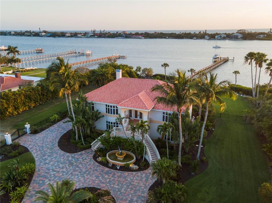 Introducing an unparalleled waterfront oasis in Englewood: A magnificent estate poised on Lemon Bay with breathtaking views of Manasota Key sunsets. The private gated entry welcomes you to a grand, brick paved driveway where you will discover 2 acres of meticulously manicured grounds. Step inside to discover soaring ceilings, and walls of windows that invite natural light and showcase panoramic water views from nearly every room. The gourmet kitchen is equipped with top-of-the-line appliances, catering to culinary enthusiasts. The open floorplan flows seamlessly between the living room, dining room and kitchen. This custom-built home was designed with meticulous attention to detail and an emphasis on waterfront living. From the lavish master suite to the four guest quarters, every corner of this home exudes comfort, elegance, and sophistication. Laundry facilities are conveniently available on each floor. The spacious entertainment room, located on the first level, features a 12' bar fully equipped with a dishwasher, ice maker, refrigerator, and wine chiller. The elevator makes transporting groceries a simple task from the first floor to the second. Embrace peace of mind as every glass sliding door is equipped with remote-controlled hurricane shutters. Step into the epitome of outdoor luxury living with a 30-foot saltwater heated pool and spa, surrounded by travertine pavers. The tropical landscape completes the picture-perfect setting, with lush greenery and wispy palms. This oasis invites you to unwind in style! 
Embark on aquatic adventures from the comfort of home with direct boating access to the Gulf of Mexico. This premier waterfront estate features not one, but two boat lifts—capable of hoisting 20,000 lbs and 10,000 lbs respectively—providing unparalleled convenience for seafaring enthusiasts.  
 For the automotive hobbyist, you will also find a 2-car garage attached to the main residence, as well as a separate 3-car garage with a versatile space that can be used as a "man cave" or additional living area. And yet another extra-long single car garage/workshop to provide ample space for storage. This location is peaceful and quiet, yet conveniently close to beaches, golf courses, and the charming downtown areas of Englewood, Venice, and Wellen Park.