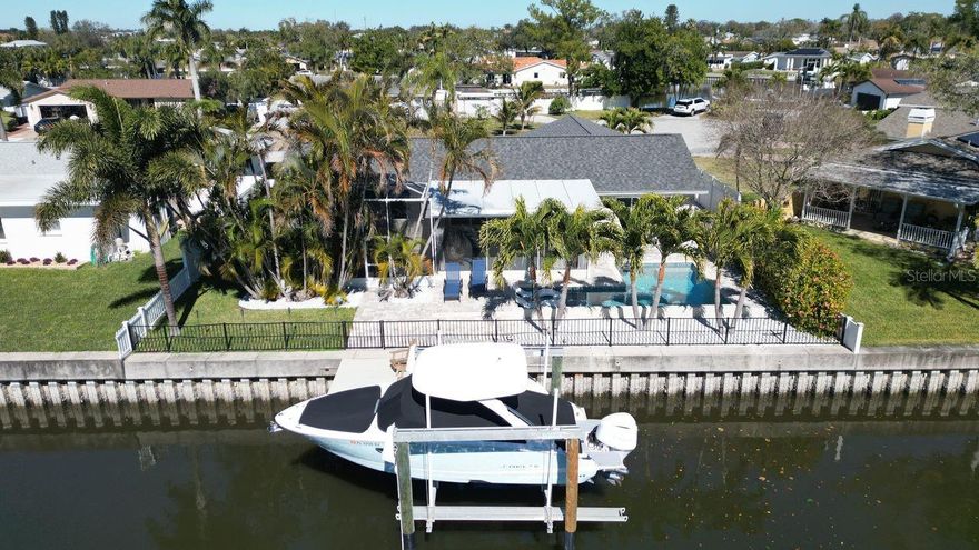 NO FLOODING—this home was not impacted. Located in the tranquil waterfront community of Waterway Estates, this beautifully updated pool home captures the essence of relaxed St. Petersburg coastal living while being tucked away on a quiet cul-de-sac just minutes from downtown. The light and airy open floor plan offers a seamless connection between the living and dining areas, making it ideal for both everyday comfort and entertaining, while the modernized kitchen overlooks the water and main living spaces, creating an inviting hub for gatherings and casual meals. Impact-rated windows and doors fill the home with natural light and provide added peace of mind. The primary suite is a calming retreat featuring serene water views, an ensuite bath with dual vanities, and a spacious walk-in closet. Additional conveniences include an interior laundry room and a two-car garage with an impact-rated door, along with major updates such as a new roof in 2024, new HVAC system in 2025, new pool in 2020, and new dock and catwalk in 2021. Outdoors, a large screened lanai overlooks the sparkling pool and peaceful waterfront, offering the perfect setting for relaxing, dining alfresco, or entertaining, with the 2020 pool surrounded by elegant pavers and lush landscaping. Boating enthusiasts will love the private dock with a 13,000-lb lift, providing easy access to the waterways and a quick cruise to downtown. Just minutes away, enjoy waterfront parks, the St. Pete Pier, local cafés, restaurants, museums, breweries, and a vibrant arts scene, along with nearby Denver Park and a recreation center featuring pickleball courts and a playground, plus convenient access to Whole Foods, Trader Joe’s, Publix, and Fresh Market—making this home the perfect blend of waterfront serenity, modern comfort, and everyday convenience.