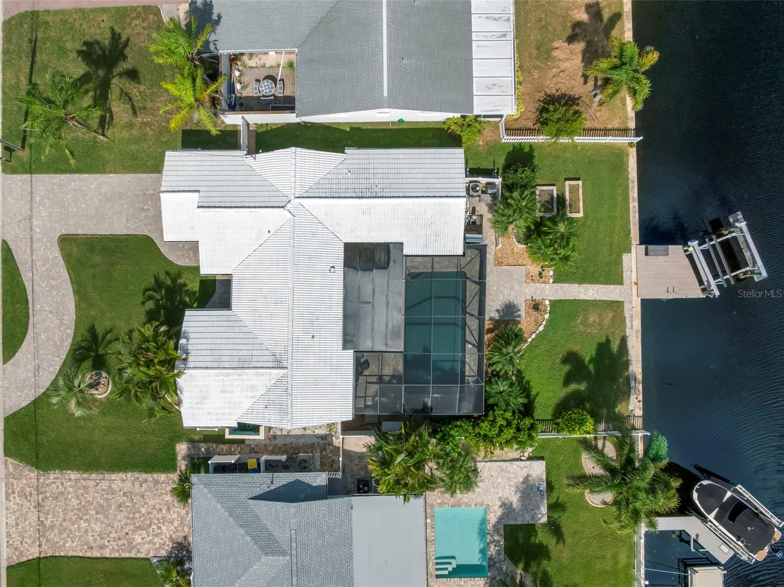 DREAMING OF YOUR OWN PEACEFUL, PRIVATE OASIS IN THIS STUNNING WATERFRONT HOME WITH YOUR BOAT IN THE BACK YARD--DOCK AND BOAT LIFT WITH ELECTRIC AND WATER ARE ALREADY IN PLACE. YOU ALSO HAVE A BEAUTIFUL SWIMMING POOL WITH A BIRDCAGE ENCLOSURE TO KEEP IT NICE AND CLEAN AND AN OUTDOOR KITCHEN (REFRIGERATOR TO BE PROVIDED BY SELLER). THE GENERAL CONTRACTOR DID A FABULOUS JOB INSIDE. THE KITCHEN CABINETS ARE BLACK AND WHITE CREATING A TIMELESS HIGH CONTRAST LOOK THAT WILL LAST FOREVER, AND THERE IS A TON OF CABINETS IN THE PANTRY THAT ARE FROM FLOOR TO CEILING. THE HOME HAS AN OPEN FLOOR PLAN WITH LOTS OF NATURAL LIGHT. LOOK CLOSELY AT THE PICTURE OF THE GARAGE WITH A BEAUTIFUL NEW POLYASPARTIC FLOOR AND A UTILITY SINK THAT ALWAYS COME IN HANDY. THE BATHROOM OFF THE MASTER BEDROOM IS STUNNING AND LIKE NO OTHER. THE PRIVATE BEACH CLUB IS JUST DOWN THE STREET. THIS HOME IS TRULY ONE OF A KIND SO HERE IS YOUR GOLDEN OPPORTUNITY. DON'T MISS OUT--COME CHECK IT OUT!!!