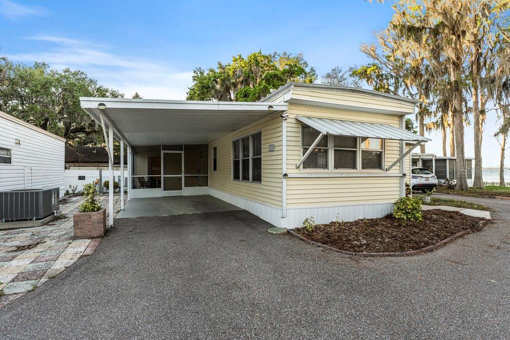 No Lot Rent! Nestled in a serene 55+ co-op community, this home offers the ultimate lakeside lifestyle. Enjoy access to a boat ramp, protected boat slips, and a short canal that leads to the Harris chain of lakes, providing endless opportunities for boating, fishing, and kayaking. The property also includes s a dock directly on the Lake Eustis with picnic tables perfect for watching breathtaking sunsets.
Step inside the cozy family room with scenic lake views, ideal for relaxing in your favorite chair. The great room is filled with natural light, thanks to numerous windows that brighten the space. For added convenience, there’s an attached shed off the screened patio. The Laundry is conveniently located off the bedroom.
Whether you’re seeking peaceful moments to birdwatch or you prefer a little more action, the community clubhouse offers fun options, like pool, card games, or simply socializing with friendly neighbors. You’ll also find the Tavares waterfront entertainment district, shopping, and healthcare just a short drive away.
Come experience the peace, serenity, and fun of this beautiful community — it’s the perfect place to call home!