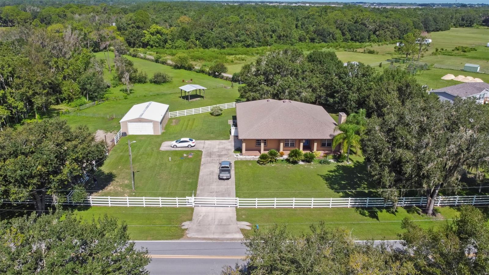 Enjoy peaceful country living on just under 5 acres with this 4-bedroom, 2.5-bath home in Winter Haven. Offering 2,549 sq ft, the split floor plan includes a spacious kitchen with breakfast nook, bar seating, and pantry, a family room with wood-burning fireplace, and a formal dining room. The primary suite features dual vanities, walk-in shower, soaking tub, and walk-in closet, while additional bedrooms share a full bath with lanai access. A fourth bedroom/flex space with half bath adds versatility. Outside, the fully fenced property boasts 2 pole barns, a stand-alone garage perfect for equipment storage, and plenty of space for livestock, RVs, or boats - all with no HOA. Call today for your private showing!