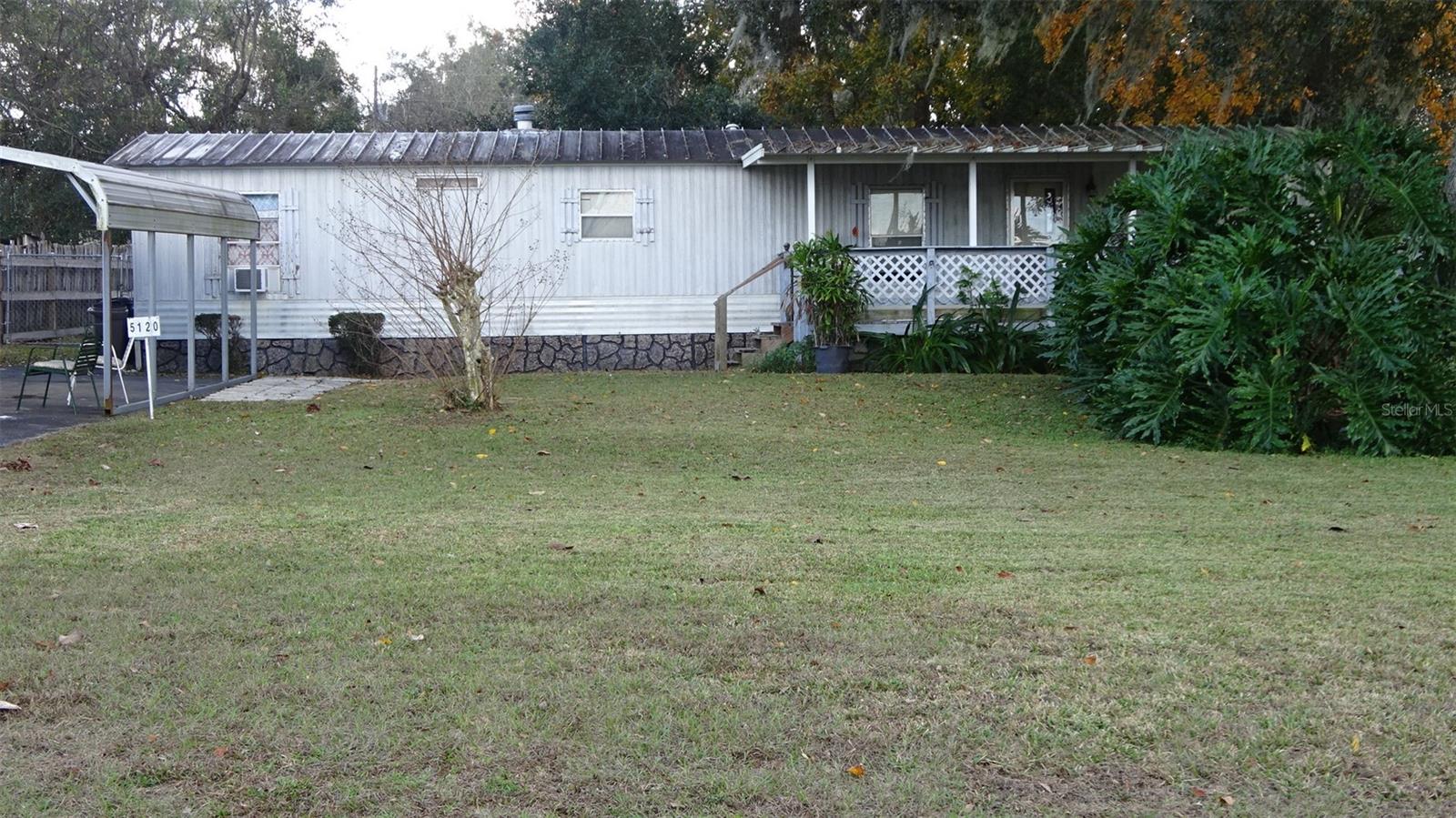 No HOA on this property. Needs updating but can be a great home or investment. Has 2 bedrooms and 1.5 bath with carport, sheds and fenced yard. Easy commute to The Villages and main highways.