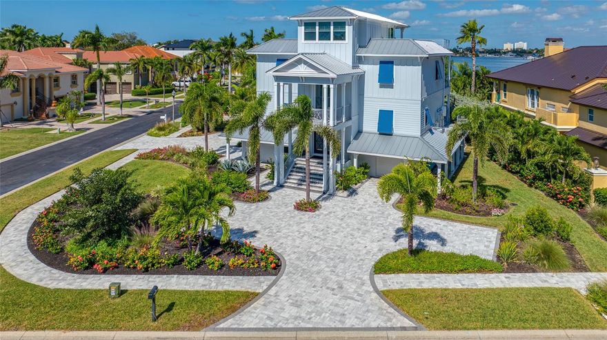 Welcome to this exceptional elvated Key West style 4-bedroom, plus rooftop bounus room , 4-bathroom, 4 car garage custom-built residence with breathtaking views of Boca Ciega Bay, in the prestigious gated Pasadena Yacht & Country Club. The home was completed December 30th 2021 to the highest coastal construction standards and thoughtfully designed to capture the panoramic and coastal views, while offering luxurious living across four levels, which are all serviced by a residential elevator. The grand staircase leads to the main entry with double front doors, setting the tone for the elegance and craftsmanship found throughout. On the first living level, you'll find three spacious bedrooms, including one with its own ensuite, a shared bathroom, a family room or study, and a laundry room. The 2nd living level features a large master suite with ensuite, an open-concept great room with surround sound, dining area, chef’s kitchen with pantry, and a guest bath. Crowning the home is a versatile Cupola on the 3rd level, perfect as an office, guest room, or entertainment area to soak in coastal views, spectacular sunsets, and holiday firework displays. This top-floor retreat is cooled by a dedicated mini-split AC unit. All floors have large balconies. 
The epoxy-coated garage level accommodates 4 cars plus a golf cart, includes a workshop area, hanging storage shelves, and is pre-wired for EV charging (3 vehicles). This home is packed with high-end features, including but not limited to: York high efficiency, low decibel cooling and heating pump, Lorex security cameras system, all house generator 22kw Generac (propane), 4 level residential elevator, all custom build wood cabinetry with Quartz countertops, automatic rainbird irrigation system via inground well, smart appliances, 250 gl inground propane tank and so much more. 
The home sustained NO flood damage during the 2024 hurricanes, underscoring its superior construction and resilience.
Located within the serene, park-like Pasadena Yacht & Country Club, residents enjoy exclusive access to a world-class golf course, junior Olympic-sized pool, poolside bar/cafe, clubhouse restaurant, fitness center, tennis & pickleball courts, and private marina with boat slips (membership required). The charming coastal town of Gulfport is just a 15-minute walk away, offering boutique shopping, dining, and a popular weekly market. The home also enjoys convenient access to I-275, connecting you quickly to Tampa or Sarasota airports, Fort De Soto National Park, and the pristine beaches of St. Pete, Madeira, and Clearwater.
This is more than a home, it's a lifestyle of coastal luxury, comfort, and community, perfect for families, retirees, and anyone seeking the best of Florida living.