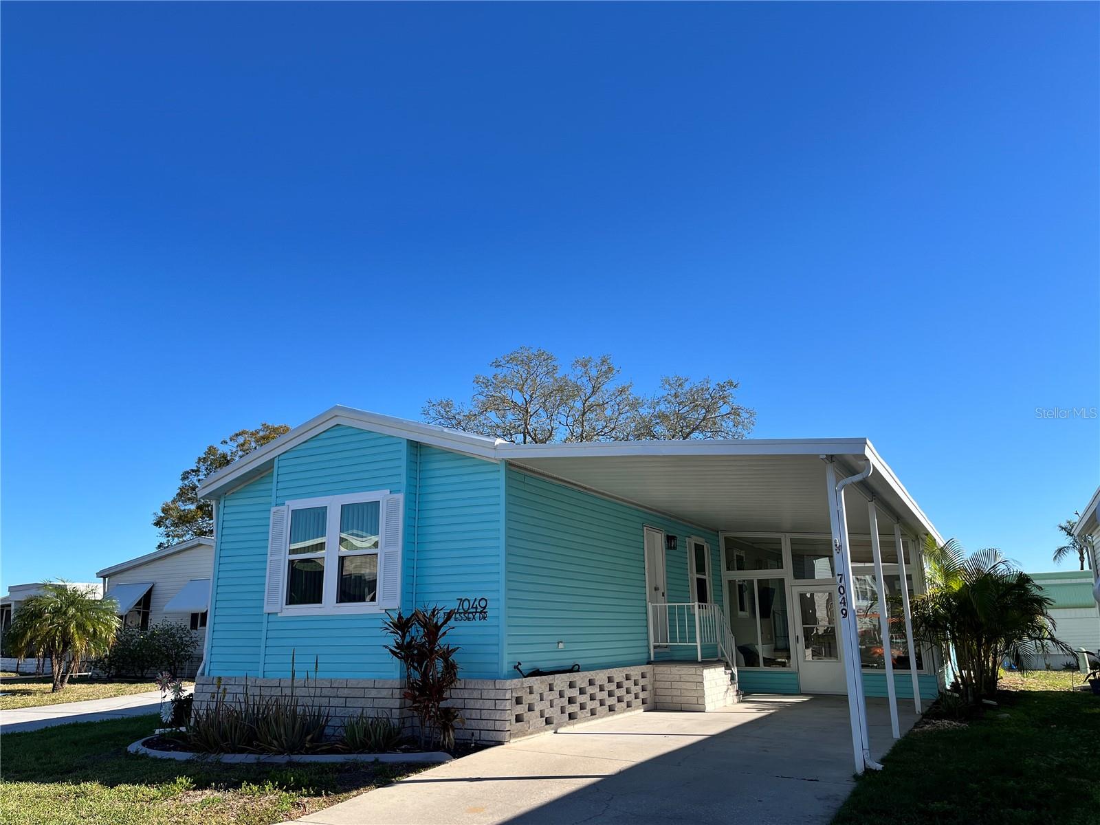 Enjoy the perfect blend of style & comfort in this 2 bed/2 bath home, nestled in the Americana Cove 55+ waterfront community. Built in 2001, this home has been completely and lovingly updated. Open concept with cathedral ceilings. Kitchen features new cabinets with soft close drawers; 2023 quartz countertops with overhang for stools; glass tile backsplash and refrigerator. Main living area features a large open space and ceiling fan. An elegant light fixture and gorgeous wallpaper (imported from Europe) were professionally installed in 2023. Spacious primary bedroom is large enough for a king size bed plus all of the extras; new contemporary ceiling fan and lots of storage capacity in the double closets. Primary bath features a large linen closet, tiled shower 2/rainfall style glass doors, soft close drawers, double towel rack and bidet. A new light fixture and pretty wallpaper were added in 2023. 2nd bedroom/office features an ample storage closet new ceiling fan and a bump out window--perfect for a desk or reading nook. Your guest will also enjoy the high quality, very comfy, queen size Murphy bed installed in 2023. 2nd bath has a tiled shower /built in seat, soft close drawers, over the toilet shelf, double towel rack and new textured wallpaper. Florida room is newly remodeled w/epoxy floors, drywall, wainscoting and ceiling fan as well as a 2022 AC mini split. The windows in the FL room showcase the beautiful exterior palms. The 3-piece cushioned wicker furniture set and mounted 55" smart tv are included with the purchase. Laundry room features: Front loading washer & dryer. There are wall mount cupboards above to hold your supplies and more. Oversized shed has space to hold your golf clubs, seasonal treasures and beach gear w/lofted shelves and pegboard. Other features include: Roof (2017), sprinkler system, landscaping, large carport, double pane windows (2021), blinds and luxury vinyl flooring throughout. In 2024 the vapor barrier and AC ducts were replaced and the exterior was painted.
Americana Cove has many features including a beautiful heated pool, hobby shop, dog park, clubhouse, bocce and shuffleboard courts as well as a brand new fitness center. There are various clubs and many fun activities such as dances, bingo, burger burns at the tiki hut by the pool. They also have decorated golf cart and boat parades during the holidays! The community has two boat ramps, kayak launch and several channels with frequent manatee, dolphin and stingray sightings! The channels give you direct access to Tampa Bay! Low HOA fee of $380 includes 24 hr. manned gate, water, sewer, trash, lawn maintenance and all the amenities. Price includes share for the lot and ownership in the co-op. Two dogs or cats up to 35 pounds are welcomed. Two pets total per household. Many great nearby restaurants, shopping venues as well as golf and other outdoor activities are waiting for you to explore and enjoy. Quick access to airports and gorgeous downtown St. Pete of course the St. Pete beaches and sunsets cannot be beat! Don't miss out on this stylish home; the sunny, care-free Florida lifestyle is waiting for you! Schedule a viewing today.