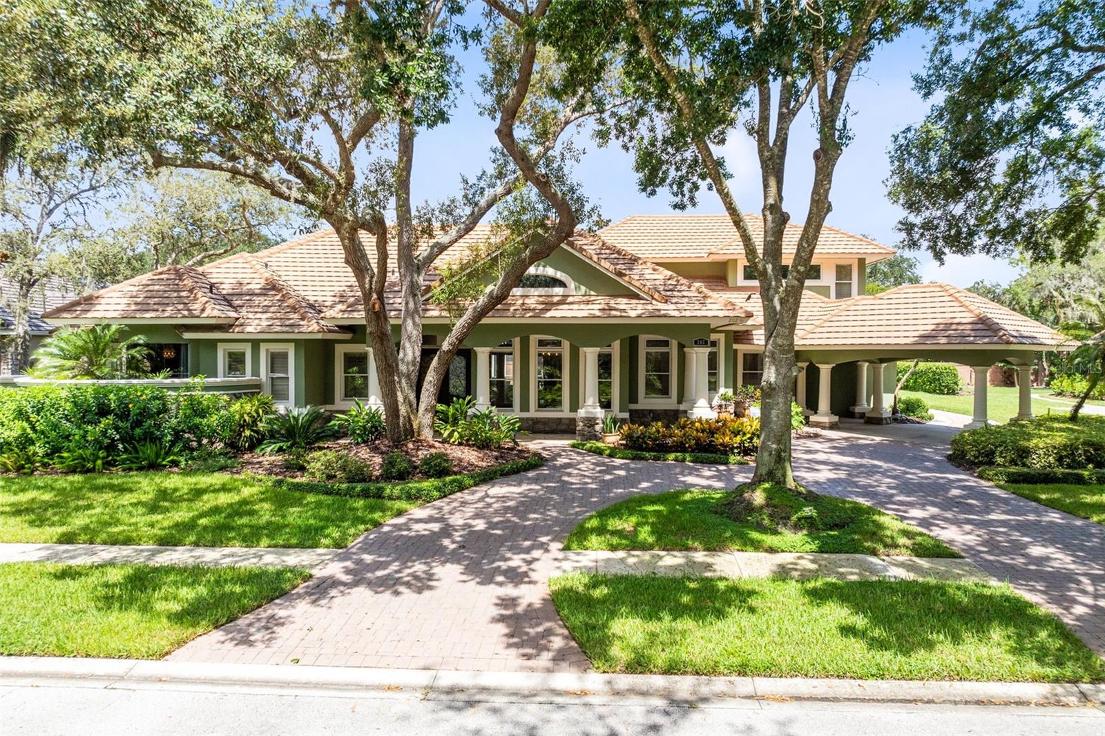 Unique, custom-built home on one half acre in the prestigious gated community of Arrowhead, the jewel of Tuscawilla. This estate is surrounded by private residences with tile roofs and stunning elevations, offering unmatched curb appeal with a travertine-adorned front porch, decorative columns, and a brick-paver circular drive with a portico leading to a rear-facing oversized three-car garage.
Inside, soaring ceilings with crown molding, decorative trays, transom windows, and custom wrought-iron entry doors create an impressive atmosphere. A magnificent double front door and separate “friends and family” entry welcome you into a thoughtfully designed floor plan.
The primary suite features two walk-in closets, a luxurious bath with a one-of-a-kind bubbler tub, dual copper sinks, vanity area, abundant counter space, and handsome lighting. An adjacent study could serve as a sixth bedroom if desired.
Additionally, the primary bedroom and secondary bedroom, the living room, family room, and study all encircle the pool and patio area for the ultimate entertaining layout. One guest suite even offers a private patio retreat.
The gourmet kitchen is a chef’s dream with 42”+ wood cabinetry with crown molding, granite countertops, large pantry, and a spacious center island. Appliances include a Café built-in refrigerator/freezer, KitchenAid stainless steel double ovens and microwave, five-burner gas cooktop, KitchenAid trash compactor, and Miele dishwasher. The butler’s pantry, conveniently located off the kitchen and dining room, offers wine storage and abundant cabinetry.
The family room features an electric fireplace with custom cabinetry, while the formal living and dining areas showcase beautiful cherry wood flooring. A giant laundry room includes Maytag washer and dryer, floor-to-ceiling cabinetry, quartz countertops, backsplash, and a utility sink.
Upstairs, a gently curved stairwell leads to a large bonus room with en-suite bath, ideal as a fifth bedroom, guest suite, media/game room, or man cave. A massive air-conditioned storage room is also located upstairs.
Highlights include:
• 4 full and 1 half baths
• Two air-conditioning systems with UV filtration
• Whole-house water filtration system
• Dual hot water heaters, including one tankless
• 9-foot interior doors with ceiling heights ranging from 10–20 feet
• French doors across the back of the home, including mitered glass in the family room
• New designer lighting fixtures
• Recessed lighting and 8” baseboards throughout
• Recent 4-point inspection confirming the top-of-the-line tile roof’s long remaining life
• Dramatic exterior and landscape lighting
The outdoor oasis features a huge heated saltwater pool and spa with cantilever edge, brick-paver patio, large covered porch, and outdoor bar with Lynx grill. Lush landscaping, privacy hedges, and a brick wall enclose the backyard, creating space for entertaining, fun, and pets to play.
This one-of-a-kind estate combines timeless elegance, modern upgrades, and thoughtful details in one of Tuscawilla’s most sought-after neighborhoods.