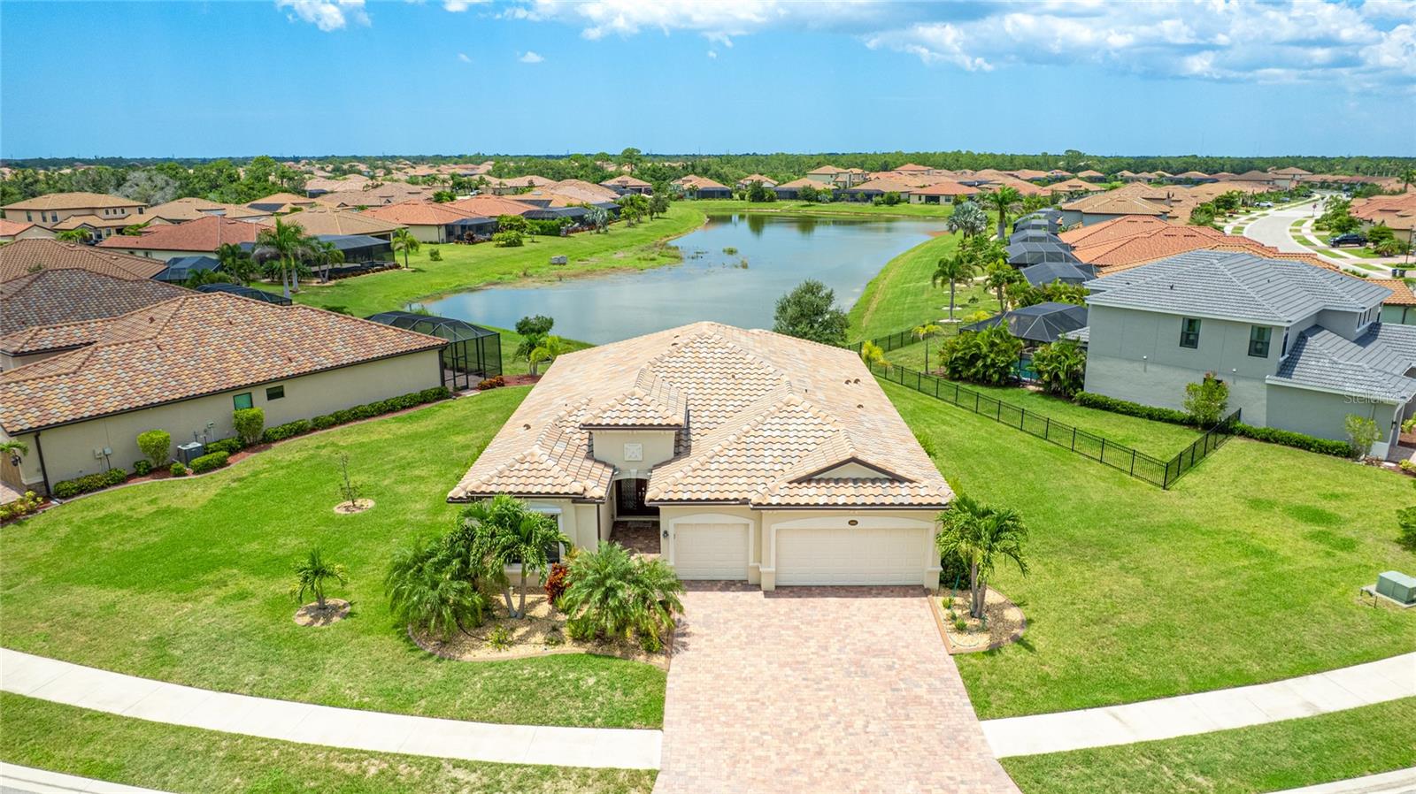 HUGE HOMESITE!...unheard of size for local, amenitized communities. Nestled in the distinguished gated community of Gran Paradiso within Wellen Park, Florida, this lovingly maintained Summerville floorplan home is a rare find, offering an expansive 1/3-acre lot—one of the largest in the community—at a highly competitive price. With living space spanning 2,444 sq.ft., this meticulously designed residence features 3 bedrooms, 3 bathrooms, a versatile den, and a spacious 3-car garage, making it one of the most sought-after floorplans in Gran Paradiso, seldom available on the market. The kitchen is equipped with updated soft-close technology cabinets, under cabinet lighting, a unique Rev-a Lift Mixer Cabinet, and Shelf-Genie custom cabinet pull-out shelves. Soft-close cabinets were also installed in the master bath, plus custom closets all 3 bedrooms. Storm Smart hurricane shutters were installed with the lanai screen/shade on a remote. Shelf-Genie pull out shelves were added to the master bath. Other features include: garage storage shelve, custom book shelf and desk in den, pull down attic access in garage, Kinetico R/O drinking water system in kitchen, Kinetico whole home water softener, full gutters, and French drains The open-concept great room, accentuated by elegant tray ceilings, boasts a large kitchen island, ideal for entertaining and daily living, with an impressive double door entry welcoming you into a bright and airy interior. The luxurious master suite, also featuring tray ceilings, leads to a spa-like master bath with his and her walk-in closets, separate vanities, a large garden tub, and a spacious walk-in shower. The oversized lot offers a serene long pond view and ample space for a pool, a fenced pet area, or other outdoor amenities. Equipped with roll-down shutters on the lanai and easy-to-close storm shutters on every window, this home ensures peace of mind during storm season. Tile flooring throughout living area adds sophistication and low-maintenance luxury. Residents of Gran Paradiso enjoy resort-style amenities, including a clubhouse, pool, fitness center, and tennis courts, all within the vibrant Wellen Park community, close to shopping, dining, top-rated schools, and Florida’s beautiful Gulf Coast beaches. Don’t miss this exceptional opportunity to own a Summerville masterpiece on an unparalleled lot at an unbeatable value—schedule your private tour today!