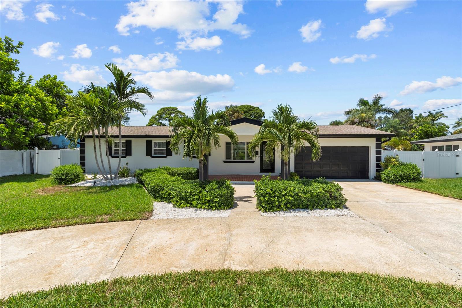 One or more photo(s) has been virtually staged. Imagine waking up to the shimmer of the canal just outside your window and stepping into a sun-filled open floor plan where modern elegance meets coastal charm. This 3-bed, 2-bath, 2-car garage home has been fully reimagined with high-end finishes, bold accents, and seamless indoor-outdoor living.
The chef’s kitchen features custom Lilly Anne cabinetry, granite countertops, premium Forno appliances, and a high-grade tile backsplash with striking gold accents. A custom wet bar with granite counters, wine racks, wine cooler, and extra cabinetry is ready for effortless entertaining. The living area centers around a built-in entertainment wall with recessed cubbies and an electric heated fireplace that invite cozy evenings with friends or quiet nights in. Just beyond, an enclosed Florida room stretches toward the water, creating a versatile space to dine, relax, or simply watch the sunlight dance across the pool.
The primary suite boasts a large walk-in closet and tulum-inspired bath featuring dual vanities, diamond sinks, frameless shower doors, a dual rainfall shower with separate handle, and a custom LED niche for shampoo and conditioner. Two additional bedrooms with deep closets share a beautifully updated bath with modern tile and elegant gold accents. and a custom wet bar with wine cooler is perfect for entertaining.
Outdoors, enjoy a covered kitchen, sparkling pool with hot tub, lush landscaping, and a new dock and boat lift with direct Gulf access. Major upgrades bring peace of mind: AC (2019) with new vents, generator (2021), tankless gas water heater (2014), updated electrical, FEMA-approved cement board walls to 4 ft, retextured interiors with new baseboards, fresh interior/exterior paint, elastomeric American coating on the flat roof and much more.
Located in the desirable Shore Acres neighborhood—known for its excellent schools, scenic parks, and friendly community—you’re just minutes from downtown St. Pete. Whether it’s morning coffee by the water, weekends by the pool, or sunset cruises from your own dock, this home delivers the best of Florida living in style.