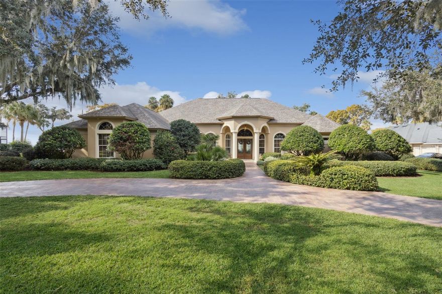 Welcome to The Peninsula—one of Central Florida’s most coveted addresses on the Harris Chain of Lakes, offering unmatched serenity, postcard-worthy sunsets, and a true waterfront lifestyle just minutes from Orlando. This beautifully appointed 3-bedroom, 3-bathroom split floor plan home combines luxury, comfort, and resort-style living in a setting that feels worlds away yet remains wonderfully convenient.

Step inside and immediately take in the sweeping west-facing lake views visible from nearly every main living area. The resort-inspired primary suite is a private sanctuary featuring French doors that open directly onto the pool deck, dramatic water views, dual custom walk-in closets, and a completely custom-remodeled spa-like bath with a deep garden tub and doorless walk-in shower—your own tranquil retreat after a day on the lake.

Designed for both everyday living and unforgettable entertaining, this home offers multiple spacious living areas anchored by panoramic lakefront scenery, plus an office/den/bonus room ideal for working from home or creating a quiet reading hideaway. The chef’s kitchen boasts a gas range with upgraded exterior venting, abundant prep and storage space, a center island with built-in storage, walk-in pantry, and breakfast bar—perfect for cooking, hosting, or simply enjoying morning coffee with waterfront views.

The living room features a stylish wet bar and flows seamlessly out to the expansive lanai and refinished pool deck, where a Pebble-Tec heated pool and spa invite you to swim, relax, or entertain beneath the evening sky. With 156 feet of lake frontage, a new dock, covered boathouse, and boat lift, this property is a dream for fishermen, boaters, and anyone who loves life on the water.

Upgrades include a 2019 roof, 2023 whole-home generator, new gas water heater, newer HVAC, and a freshly re-sealed paver driveway. Tray ceilings, large windows with plantation shutters, and nearly an acre of land add to the spacious, elegant feel of this exceptional home.

The community itself feels exclusive, featuring its own private road and a brand-new gated entrance scheduled to be installed this February—enhancing privacy, security, and curb appeal.

Located in Tavares—America’s Seaplane City—this is lakefront living at its finest, where every day can feel like a vacation. Whether you're watching unforgettable sunsets from your pool, hosting friends for waterfront evenings, or heading out on the Harris Chain for a day of adventure, this home delivers a lifestyle that is truly unmatched.