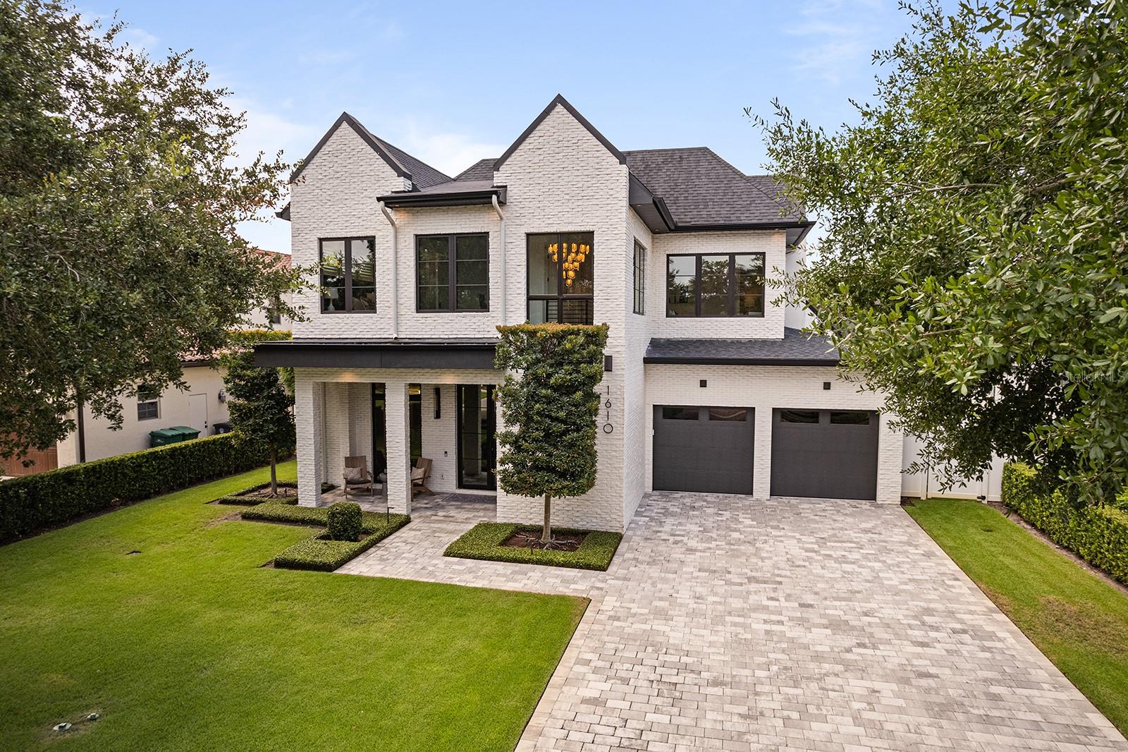 This stunning modern farmhouse residence, custom built in 2021 with meticulous attention to detail offering a bright-open living design, luxurious finishes, and an ideal floor plan for both everyday living and grand-scale entertaining. This home includes 5 en-suite bedrooms (owner’s suite & potential guest suite on 1st level) and 3 Bedrooms, plus lounge/flex area upstairs… or a 4 Bedroom, office + lounge/flex area… and 5 full baths + 2 1/2 baths. The entire property has been maintained in “better than new” condition featuring gorgeous light wood flooring that transcends the entire home with elegant herring bone design throughout the entry foyer. The open-concept layout is flooded with natural light thanks to walls of sliding glass doors, including a disappearing wall that seamlessly connects the indoor living spaces with the incredible outdoor transitional lanai that is really cool to enjoy outdoor living and has its own mini-split AC system. The chef’s kitchen is a showstopper, featuring top-of-the-line appliances, a large island with seating, integrated refrigeration, wine fridge, and a hidden butler’s pantry with an additional refrigerator—all open to the spacious dining and living areas. The living room showcases floor-to-ceiling windows, a striking fireplace with built-ins, and tranquil views of the beautifully landscaped yard and pool. The private first-floor primary suite features direct access to the backyard and a spa-like bath with a soaking tub and oversized glass shower. A second first-floor bedroom suite, currently used as an office, provides versatility for guests or multi-generational living. Upstairs, there is a spacious lounge area and 3 additional ensuite bedrooms all featuring walk-in closets… The outdoor lanai offers a summer kitchen, gas fireplace, and remote-controlled screens under soaring wood ceilings, creating a perfect year-round gathering space…. Complimented by a resort-style pool and heated spa surrounded by lush tropical landscaping and manicured bamboo for total privacy... Additional highlights include a drop off/mudroom zone off the two-car garage, a generous laundry room, and an ideal location on a charming brick street just minutes from Park Avenue’s shops and restaurants. Zoned for top-rated public schools and near elite private schools, with easy access to Phelps Park, YMCA, ICC, WPRC and Park Avenue—this exceptional home checks every box!