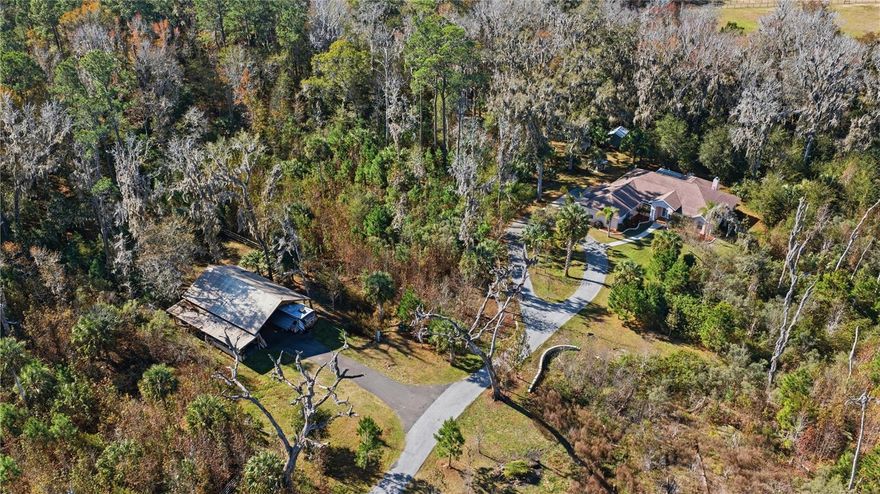 NEW ROOF Coming Soon – Buyer’s Choice of Color! Welcome To Your Own Private Sanctuary! Discover the perfect blend of elegance, comfort, and natural beauty unfold across 10.29 acres of income-producing tree farm land. An adjacent 11.91-acre parcel is available for separate purchase. Located just 5 minutes from the Jockey Club and a 25-minute drive from Ocala and the World Equestrian Center. A gated entrance and picturesque winding road lead to this generous custom-built residence, nestled in a serene park-like and forest setting. Featuring; 3 Bed/2 Bath + den/office spanning over 2,500 heated sqft., open split plan, soaring ceilings, rich wood accents, cozy gas fireplace, laundry room, sideload 4-car garage, and spacious lanai/Florida room ideal for relaxing and entertaining. The equipped kitchen boasts granite counters, solid wood cabinetry, high-end appliances, and breakfast nook. The owner’s suite offers a private retreat, garden tub, glass enclosed tile shower, separate vanities, and a walk-in closet. Outdoor features include; a 30x48 pole barn with a 360 sqft. unfinished barn office/loft, new 50-amp RV hookup, 20' bay to house your RV, boat, camper or travel trailer, 2-horse stall barn with paddocks, and lean to shed. Newly added whole house generator, water softener, storage/garden shed, and underground wiring enhance utility and efficiency to the property. Immerse yourself in your beautiful plantation overlooking your scattered large oaks, palm trees, and pines. Wander along scenic trails, enjoy the peaceful sounds of nature, and fascinating wildlife. There is a dry creek bed installed in the property designed to channel and manage rainwater runoff to prevent erosion and flooding and aid in water conservation. This property has the capacity to generate its own power via a commercial propane generator. It also has the potential to become a thriving hub of activity, offering endless opportunities for growth and success. Recent and pending upgrades include; NEW 2026 Roof, Whole House Generator 2022, and HVAC system 2021. This property isn't just a home; it's a lifestyle! Whether you’re seeking an exclusive family compound, a retreat property, or a unique income-producing homestead, this enchanted haven delivers it all.