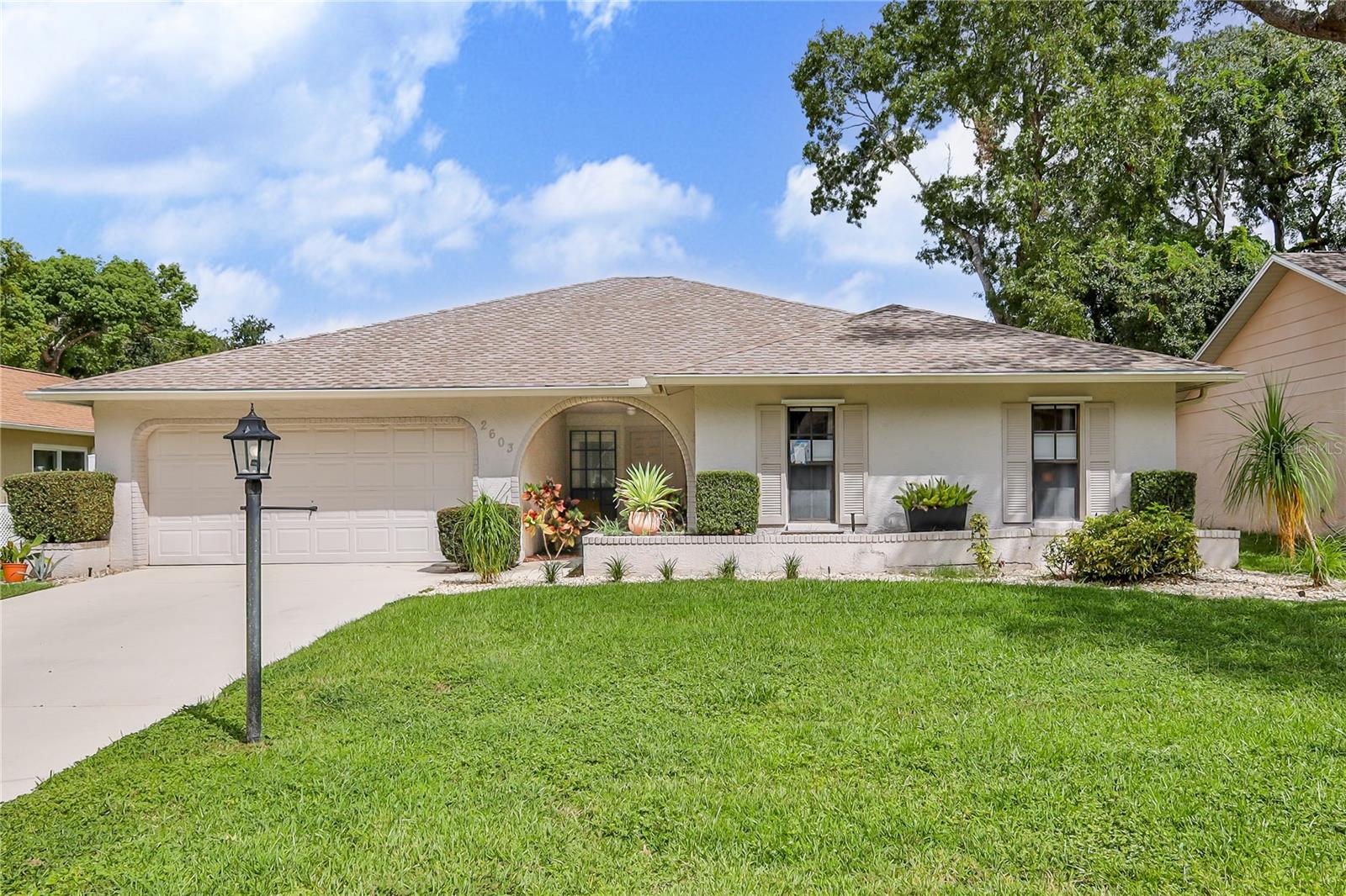 Welcome to this beautifully updated and tastefully decorated 2-bedroom, 2-bathroom single-family home, where modern touches meet comfort and functionality. From the moment you step through the elegant double front doors, you'll notice luxury vinyl plank flooring flowing throughout the home and a thoughtful floor plan designed for easy living. The layout features a formal living room and dining room, along with a versatile flex space that can serve as a family room, TV room, music room, bedroom or home office—whatever suits your lifestyle best. The updated kitchen is a highlight, boasting quartz countertops, wood cabinetry with soft-close drawers, a stylish backsplash, recessed lighting, stainless steel appliances, a closet pantry, built-in coffee station, and a wine rack—perfect for entertaining or enjoying everyday convenience. The spacious primary suite includes dual closets, a ceiling fan, and an updated en-suite bathroom with a new dual-sink vanity and a walk-in shower. The second bedroom also features a ceiling fan and closet, while the second bathroom offers modern updates and a shower/tub combo. Sliding glass doors from both the living room and flex room open to an expansive, covered, and screened lanai that spans nearly the entire length of the house—perfect for relaxing or hosting guests. The flex room includes a wet bar, barn doors connecting to the dining area and kitchen, and direct access to the lanai. The fenced side yard is perfect as a private dog run or additional outdoor space—ideal for pet lovers. Additional features include an indoor laundry room with a stainless utility sink and closet storage, a two-car garage, beautiful landscaping, and a paver patio just outside the lanai. Major updates include a new roof (2025). HVAC (2006). Remediated ground settlement with all documents fully insurable and financeable. Timber Pines, an award-winning, guard-gated 55+ deed-restricted community, provides access to an exceptional lifestyle. Residents enjoy three 18-hole golf courses, a 9-hole pitch & putt, ligted tennis courts, 12 pickleball courts, two community pools, a country club restaurant and bar, a state-of-the-art fitness center, a woodworking shop, billiards, a performing arts center, and a vibrant array of clubs and activities. This move-in-ready home combines modern finishes, smart design, and outdoor comfort—don't miss this one!