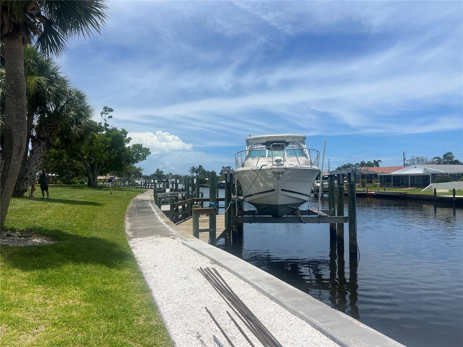 Priced well under market value for a quick sale, this incredible SAILBOAT WATER access, WATERFRONT home has a short, 5 minute ride to the Intercostal Waterway . Boasting 1566 sq.ft with 2 bedrooms, 2 full bathrooms, a Living Room PLUS a Dining Room, OVERSIDE Lanai with sliding glass doors in the Primary bedroom, & Dining room. Enjoy watching life on the canal from the lanai with your boat steps away cradled up in its lift! NEWER 2024 ROOF for your peace of mind in addition to lower insurance rates. 2018 A/C, BOAT LIFT, DOCK, new 42' cement seawall. Located in a fabulous waterfront HOA community with a low monthly fee $428. Time capsule ready for your personal touch!
