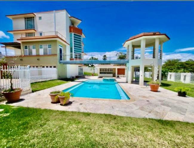 Exclusiva Urbanización con acceso controlado, residencia cuenta con vista panorámica al Mar Caribe. Cuenta con áreas de sala, comedor, family room, cocina (estufa de tope, nevera, horno y parrilla), 6 cuartos, uno es para el servicio (3 cuartos tienen terraza y todos los cuartos tienen baño. Cuarto Master tiene 2 walking closets y oficina), 7 ½ baños. Pisos en mármol y parque. Cuenta con garaje para tres vehÃculos bajo techo, dos áreas para laundry, piscina, gazebos, dos terrazas en área de piscina, cava de vinos, elevado, planta eléctrica y cisterna.