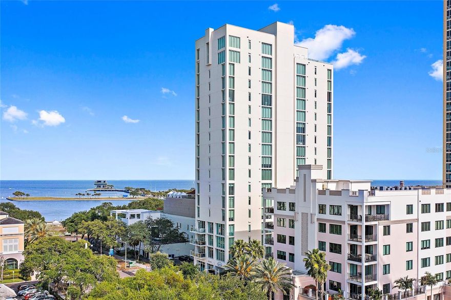 Featuring unobstructed water views and located in the beautiful, boutique-style “Bliss” building in the heart of Downtown St. Petersburg, welcome to unit 1102. This exquisitely appointed three bedroom, two bathrooms, plus one half bath residence offers over $200,000 in improvements by world renowned, local designer Rob Bowen. The immaculate workmanship, intricate attention to detail, and intelligent design this home exhibits set it apart from the rest. If privacy is of the utmost importance, then I invite you to step off the elevator and into your foyer, accessible only by you. There are only 29 residences in this building and no shared walls. Past your foyer and immediately upon entering your residence, you are greeted by a mesmerizing statement wall. If the wall doesn’t grab your attention first, then the views certainly will. To the left, a bank of floor-to-ceiling windows that run the length of the great room, showcasing the waters of Tampa
Bay, the St. Petersburg pier, and the marina. Access to your terrace provides you with that outdoor/indoor living the sunshine city is known for. You’ve never experienced sunrises quite like this. Speaking of sun, the natural light that enters the great room and kitchen are spectacular. The great room has been separated by a transparent tower of wine, making the space feel open while at the same time never blocking the reason you’ll want to own this residence: the view. To the left an electric built-in fireplace and feature wall providing texture and dimension, a mounted television and soundbar, and a hidden door granting you entry to your custom-designed storage room. To the right additional seating making this combination great room a perfect place to entertain and making the focal point, yet again, that stunning view. Just beyond the living room is the kitchen. The sunrise will wish you a good morning as you make your morning coffee. The kitchen features Viking appliances, including a gas range and vent hood, refrigerator, microwave and oven, with quartz countertops, custom
cabinetry, and a design backsplash that really brings the space together. The residence features a split floor plan. The primary suite is expertly located and provides expansive views of Tampa Bay while also featuring electric blinds, a walk-in closet, and an en-suite bathroom with a soaking tub, dual vanities and a walk in shower complete with a bench. Two additional bedrooms finish out this amazing residence, with one perfect for guests who are visiting and the other an office, your personal sanctuary and retreat that enables you the opportunity to
work from home. The building features easy-to-use, vehicular elevators and the unit comes with two parking spaces. Bliss also features a heated pool, a fitness center, a Rooftop Club-room, a terrace with an outdoor grill and large Spa and a manager on-site. Your new residence is just steps away from the eclectic array of fine dining options, cafes, museums, shopping, and the city’s renowned collection of green space, walking trails, and parks on Beach Drive. Step into comfort, sink into luxury, and fall in love with this breathtaking home.